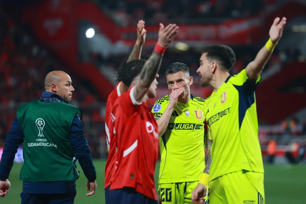 Matías Zaldivia y Charles Aránguiz mientras ocurren los incidentes en la tribuna Pavoni alta del estadio de Independiente. (Javier Vergara/Photosport).
