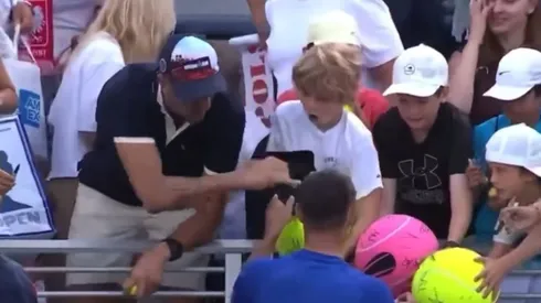 Piotr Szczerek roba un gorro a un niño en el US Open