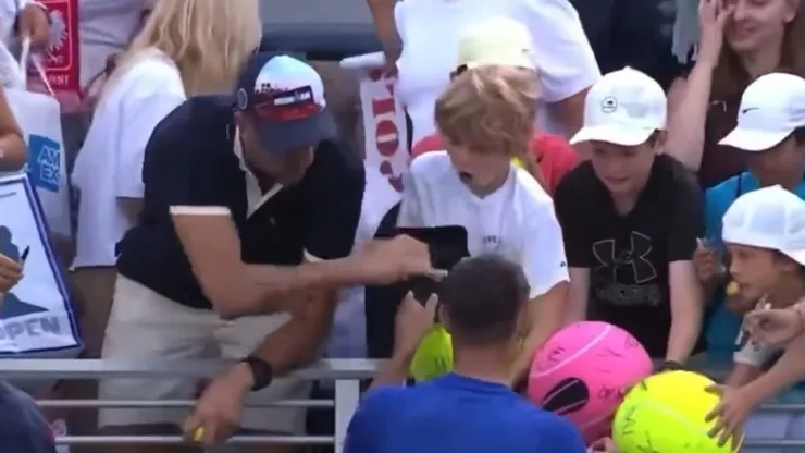 Piotr Szczerek roba un gorro a un niño en el US Open