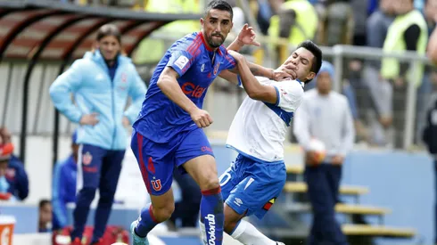 Osvaldo González disputa un balón ante Diego Rojas en un Clásico Universitario.
