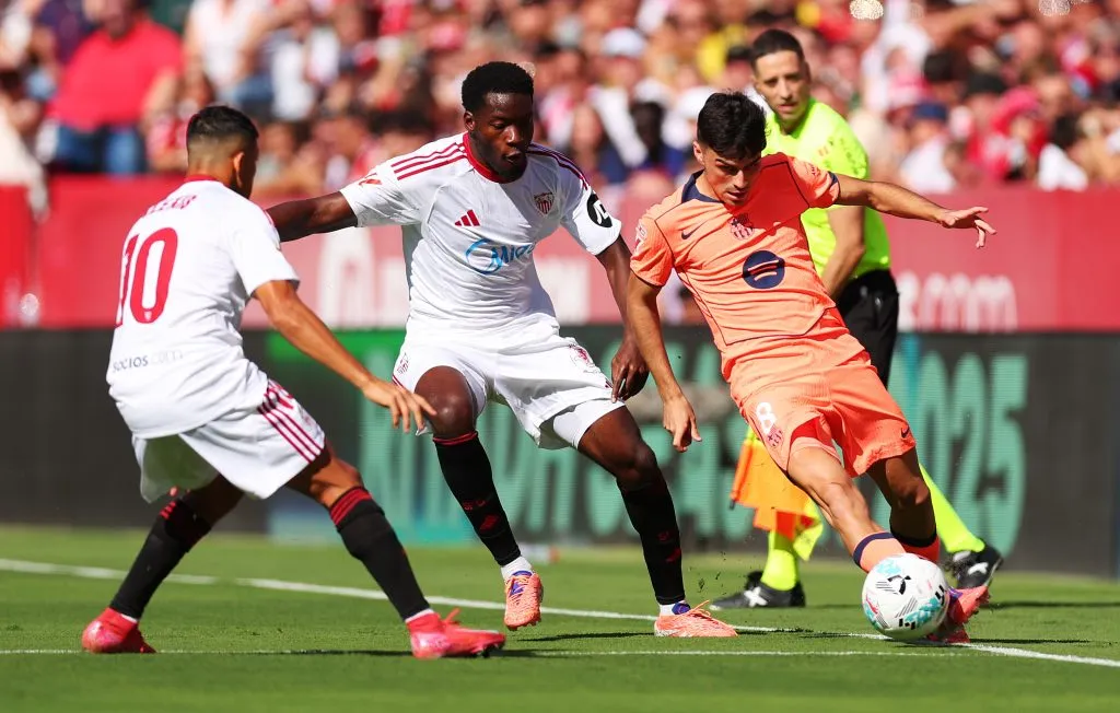 Lucien Agoumé y Alexis Sánchez presionan a Pedri en el partido que el Sevilla le ganó 4-1 a Barcelona. (Fran Santiago/Getty Images).