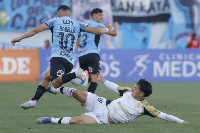 Cristián Zavala lucha una pelota con Bryan Rabello. (Jorge Loyola/Photosport).