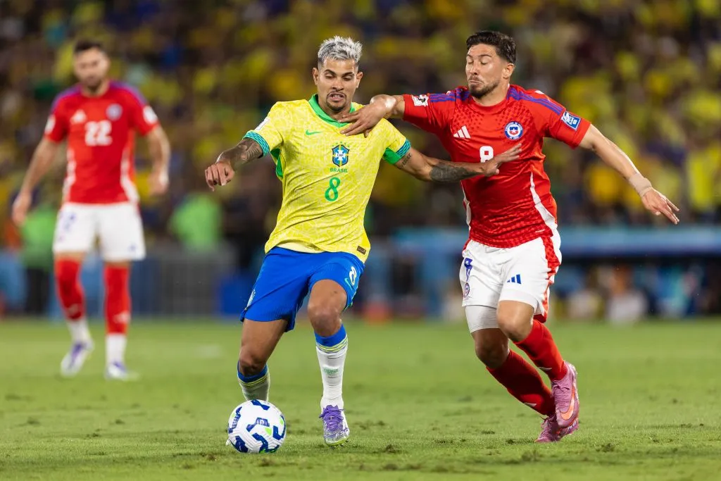 Bruno Guimaraes aguanta la marca de Felipe Loyola en un Brasil vs Chile en las Eliminatorias 2026. (Ruano Carneiro/Getty Images).