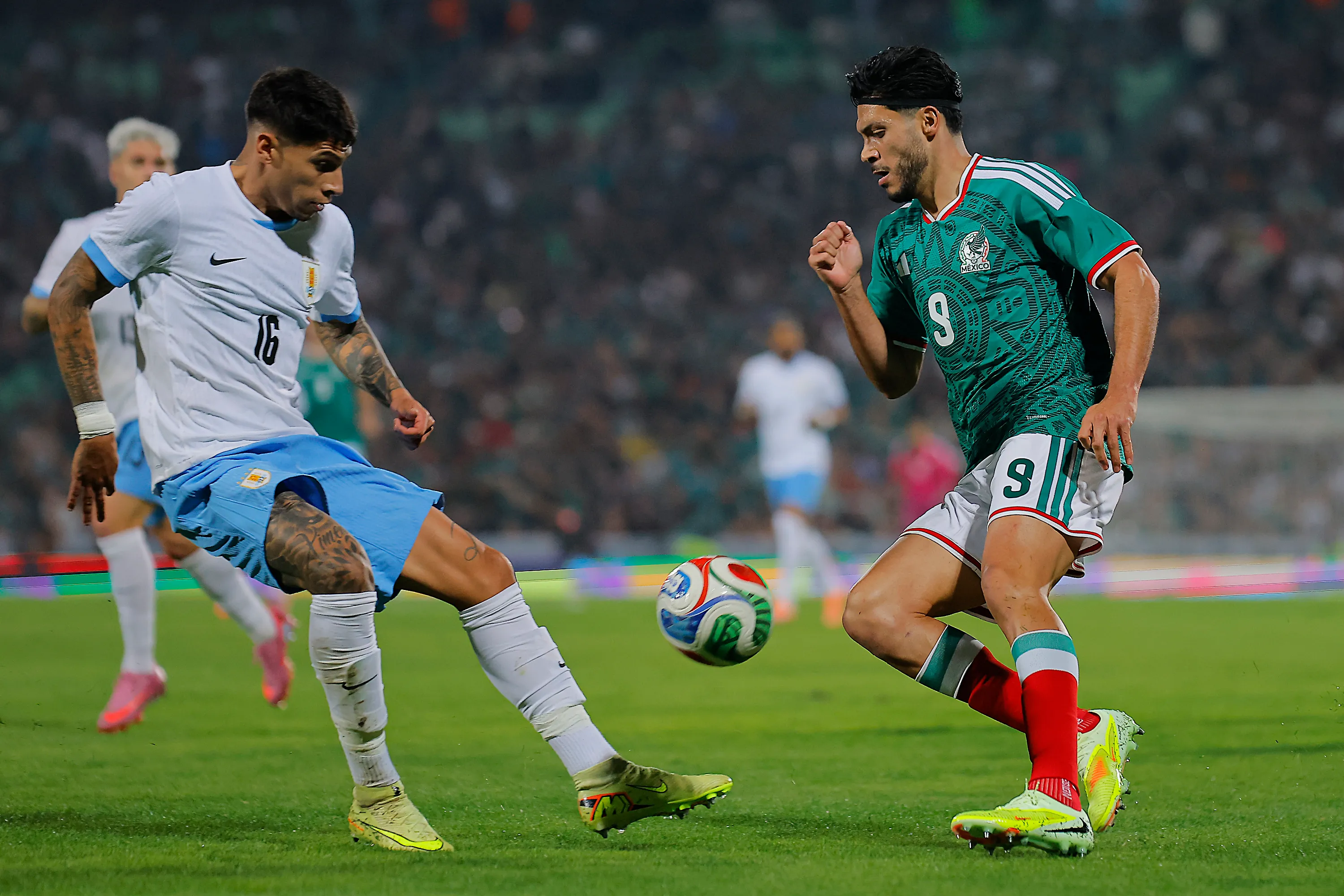 Raúl Jiménez enfrenta a Mathías Olivera en el amistoso de México ante la Celeste. (Manuel Guadarrama/Getty Images).