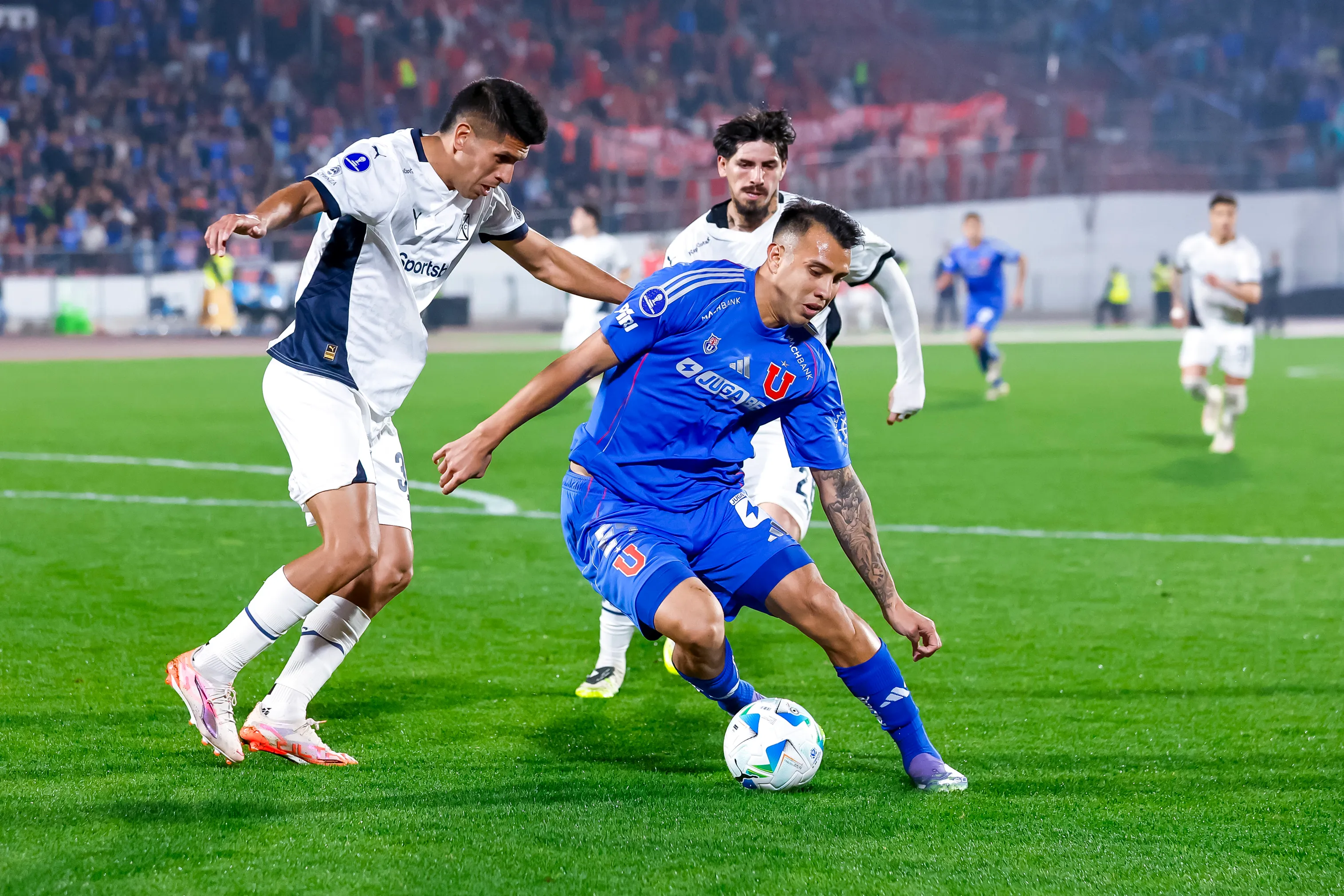 Sebastián Valdez marca a Rodrigo Contreras en la ida del duelo entre U de Chile e Independiente. (Pepe Alvujar/Photosport).