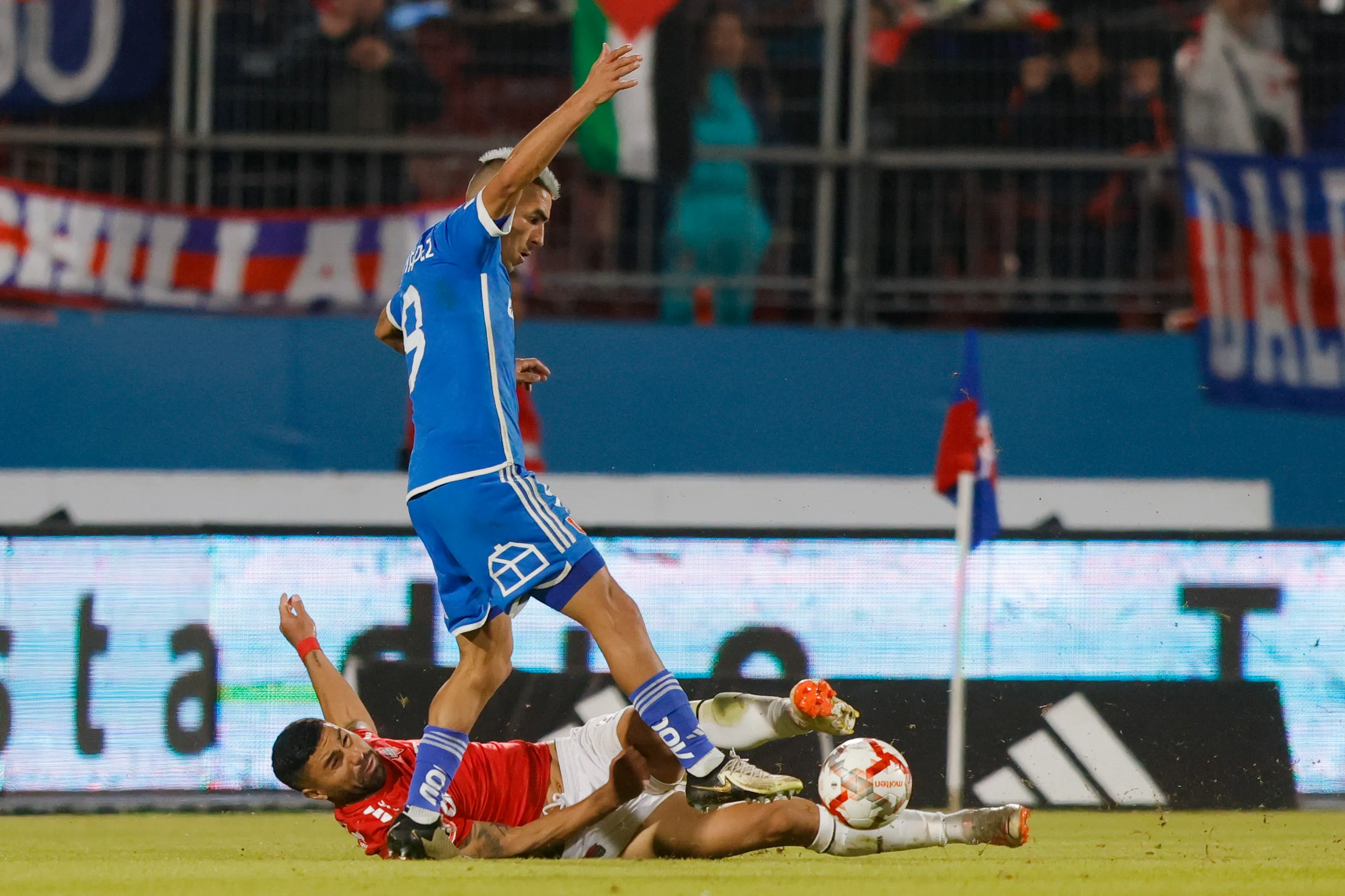 Carlos Labrín lucha un balón ante Leandro Fernández en un juego entre U de Chile y Ñublense. (Felipe Zanca /Photosport).