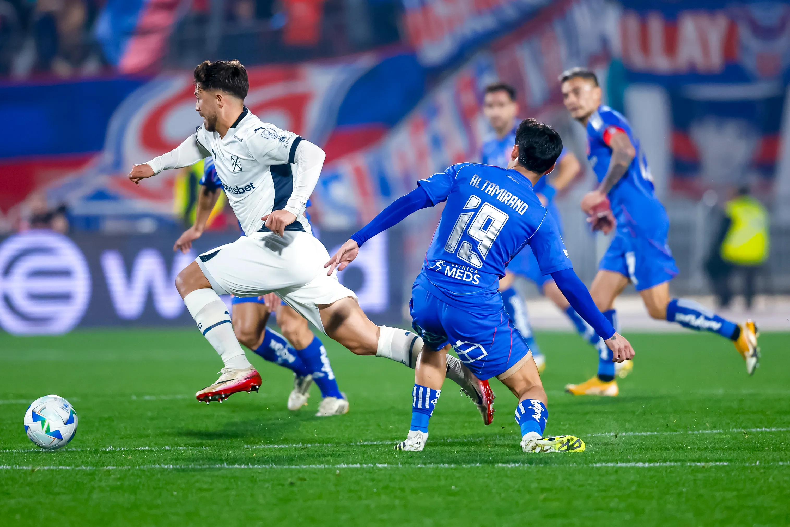 Felipe Loyola ante Javier Altamirano en el Estadio Nacional, donde la U ganó con gol de Assadi. (Pepe Alvujar/Photosport).