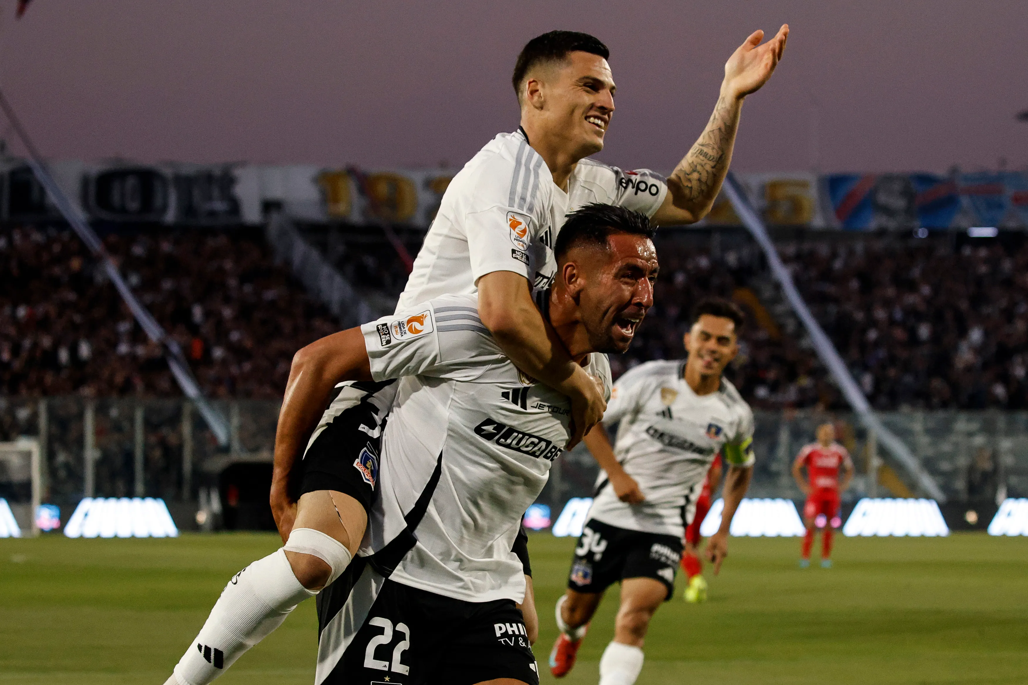 Mauricio Isla lleva en andas a Lucas Cepeda. El Huaso se fue y el zurdo, casi. (Diego Martin/Photosport).