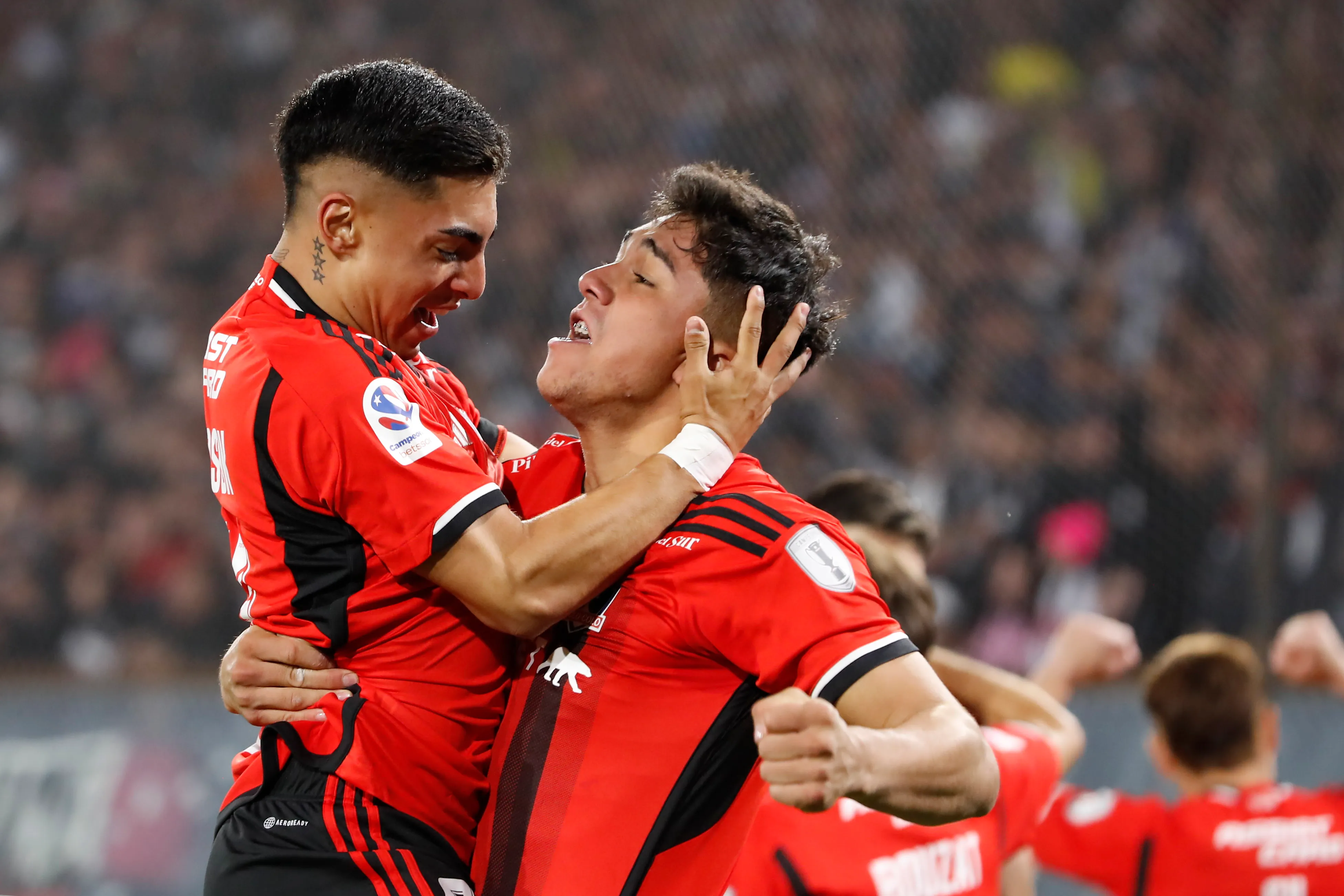 Jordhy Thompson se abraza con Damián Pizarro, quien estuvo a punto de volver. (Felipe Zanca/Photosport).