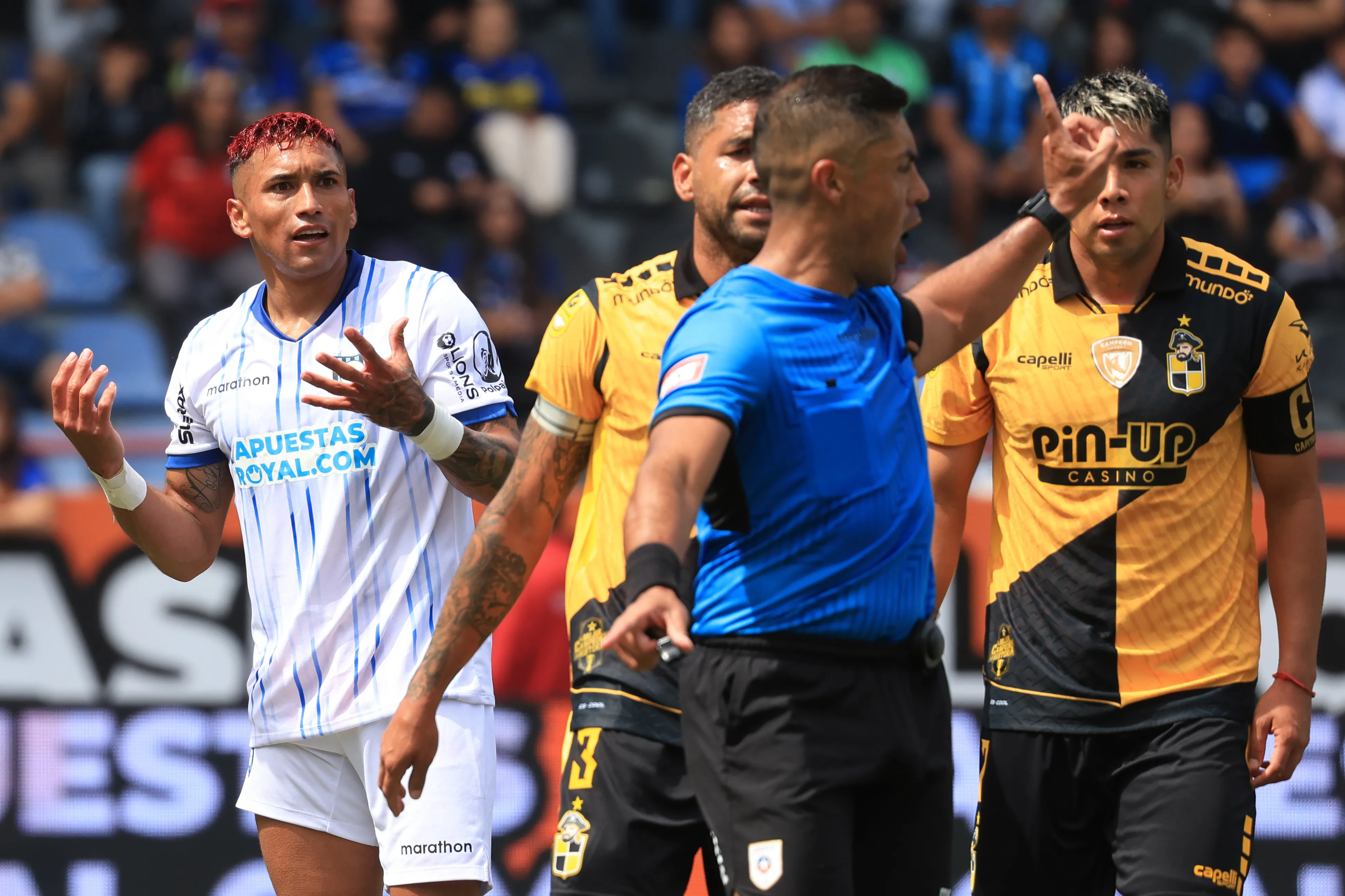 Sebastián Galani y Manuel Fernández van hacia el árbitro Nicolás Gamboa. (Eduardo Fortes/Photosport).
