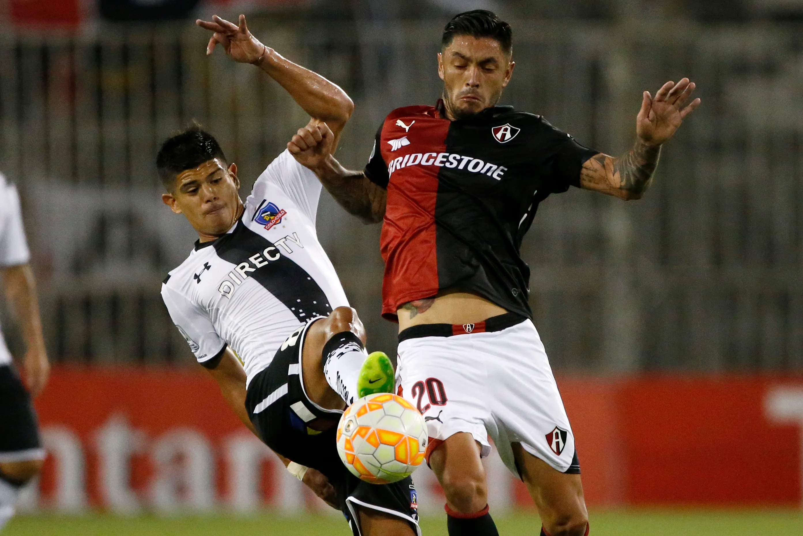 Rodrigo Millar ante Esteban Pavez en la Copa Libertadores 2015 con el Atlas de México. (Andres Pina/Photosport).