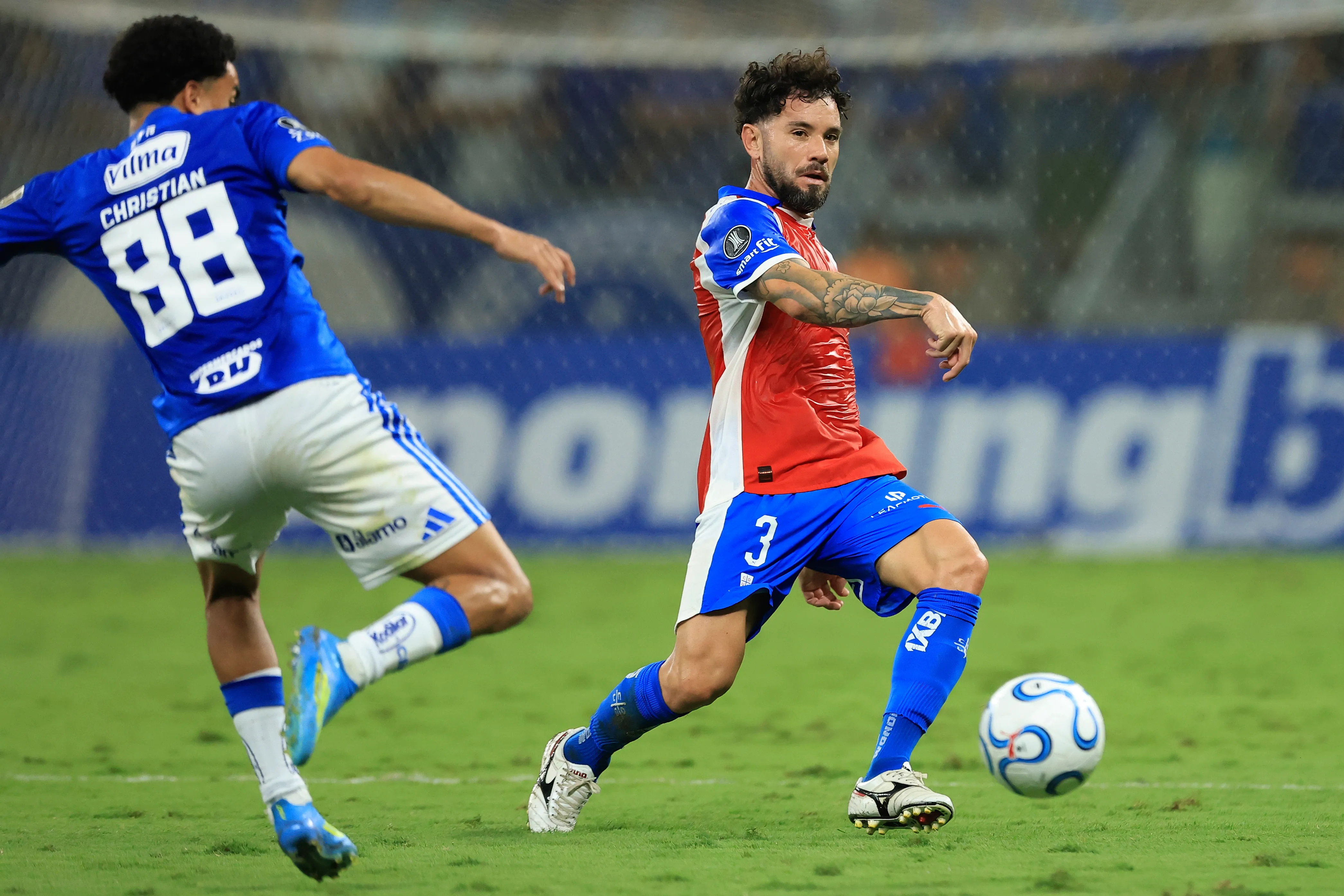 Eugenio Mena frente a Christian en el duelo que la UC le ganó a Cruzeiro en Minas Gerais. (Pier Giorgio Giavelli/Photosport).