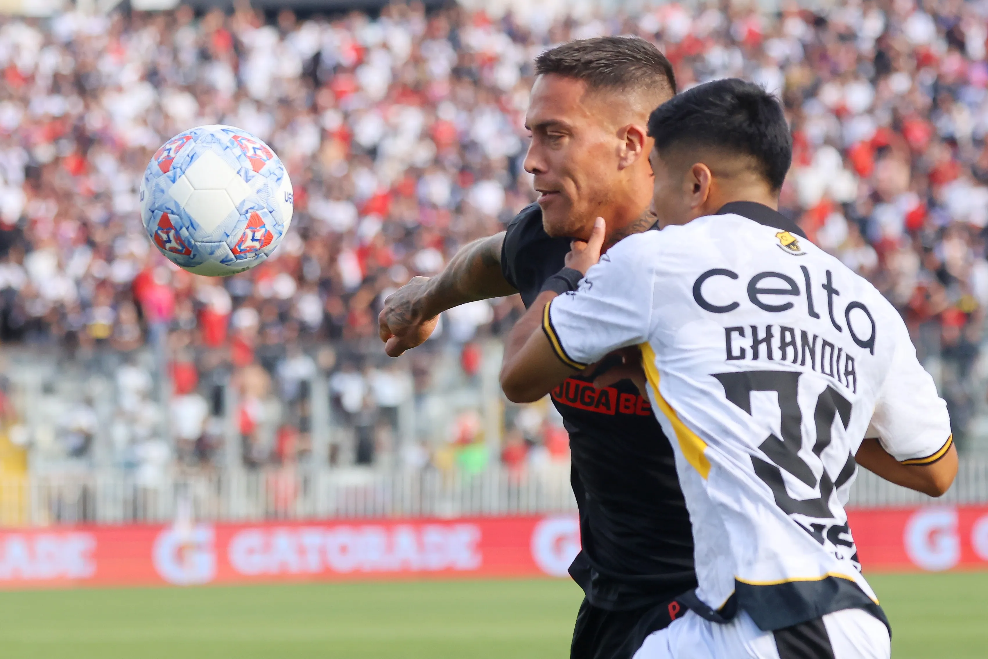 Benjamín Chandía lucha un balón contra Javier Méndez de Colo Colo. (Jonnathan Oyarzun/Photosport).