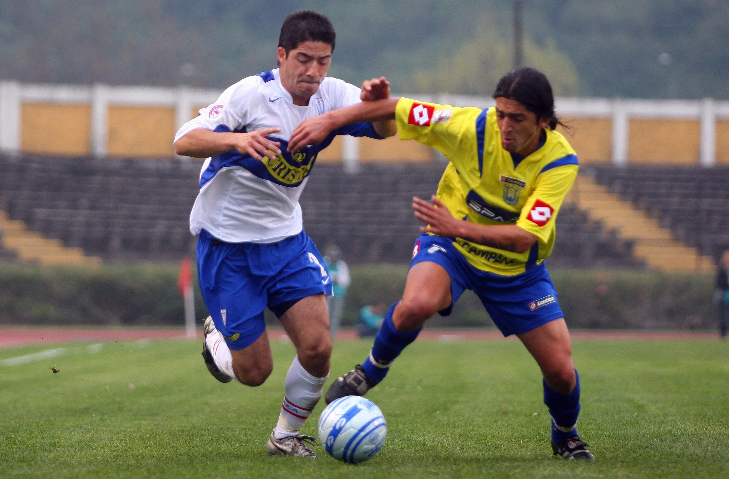 Cristián Álvarez disputa un balón contra Leonel Mena. (Photosport).