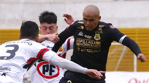 Javier Araya lucha un balón con Humberto Suazo en 2023.