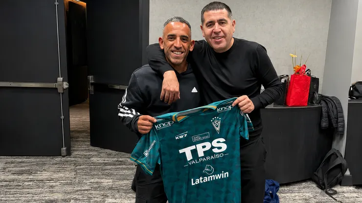 Jorge Luna junto a Juan Román Riquelme con una camiseta del Decano.