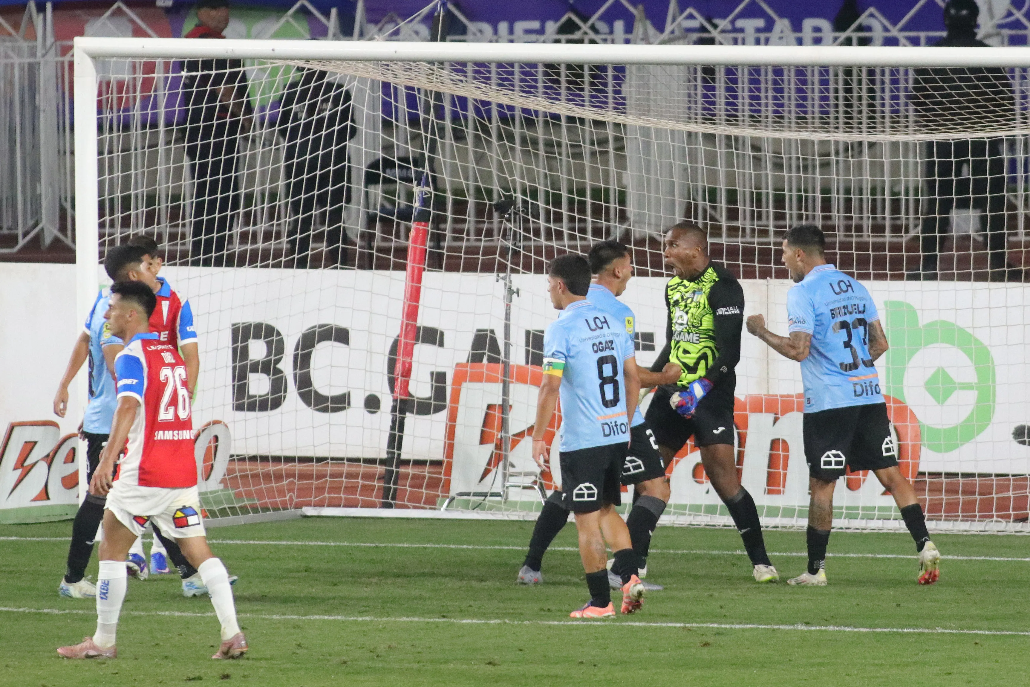 Omar Carabalí es felicitado por un tapadón a Matías Palavecino. (Jorge Loyola/Photosport).