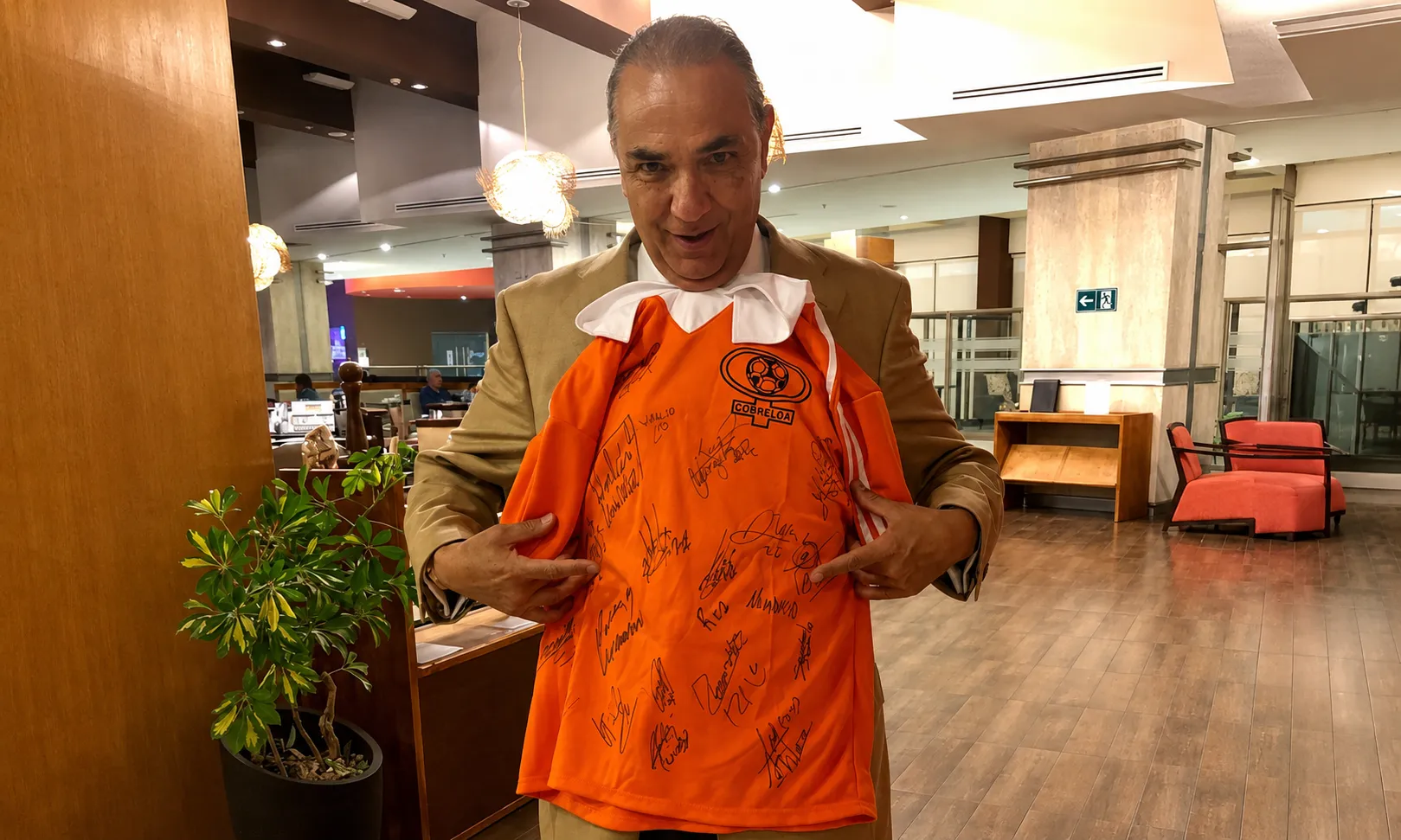 Libardo Buitrago luce orgulloso una camiseta de Cobreloa repleta de autógrafos. (Cedida y retocada con ChatGPT).
