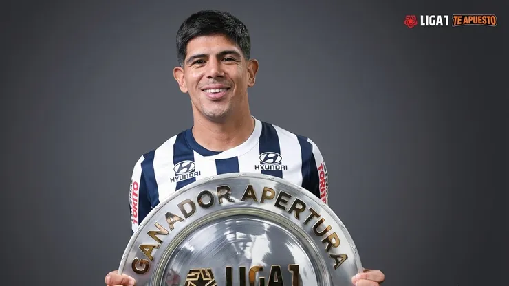 Esteban Pavez celebra junto al trofeo que Alianza Lima conquistó en el Torneo Apertura peruano.