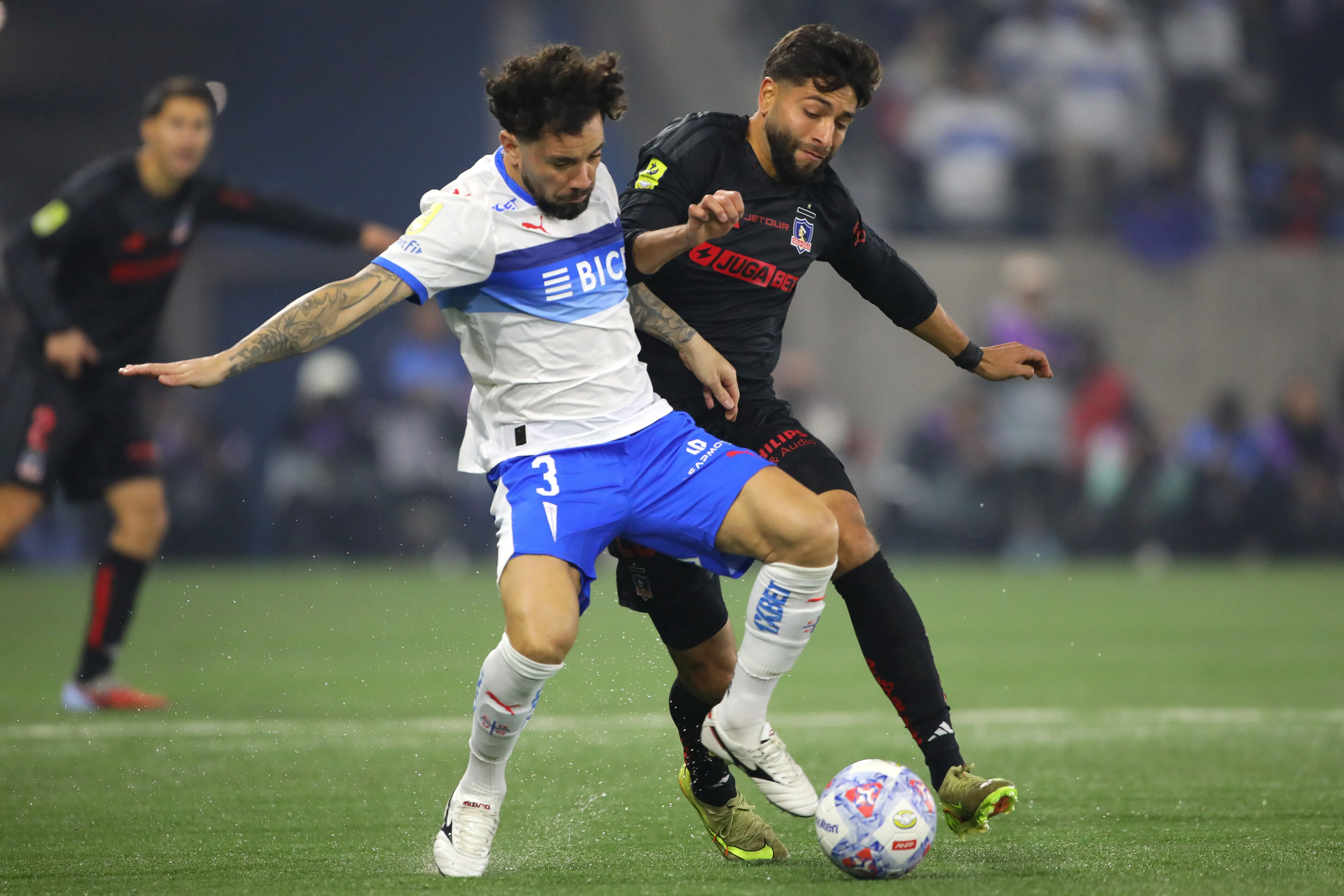Jeyson Rojas en un duelo contra Eugenio Mena en el clásico que Colo Colo le ganó a la Católica en el Claro Arena. (Jonnathan Oyarzun/Photosport).