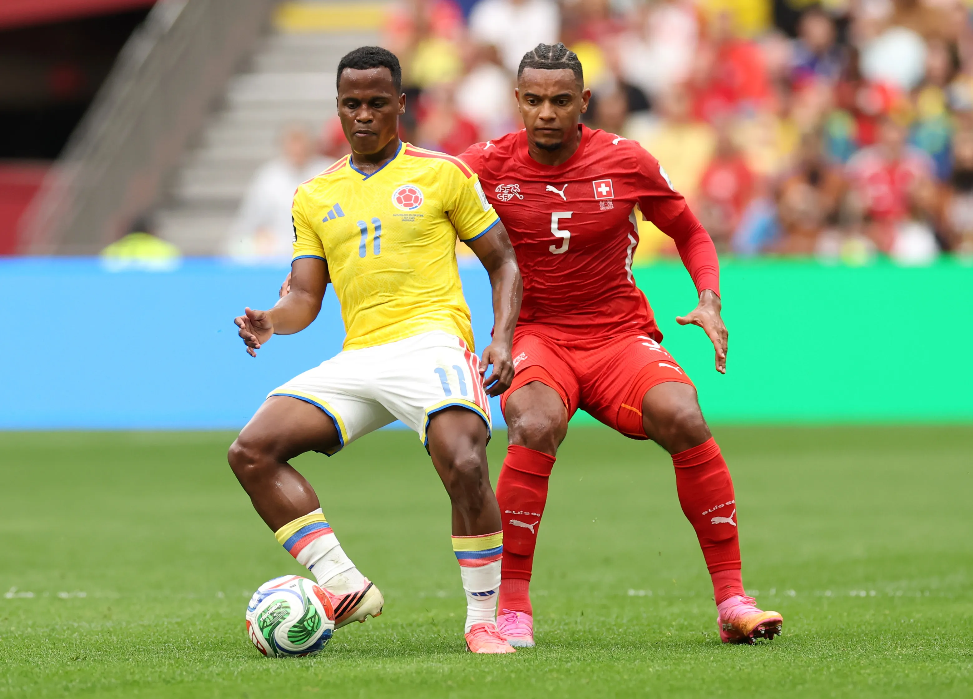 Jhon Arias resiste la marca de Manuel Akanji en el duelo frente a Suiza. (Carl Recine/Getty Images).