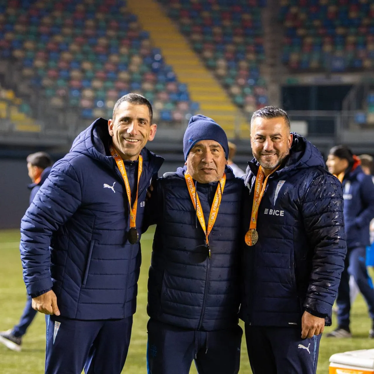 Hernán Madrid (a la derecha) celebra junto a trabajadores de Católica el título Sub 20