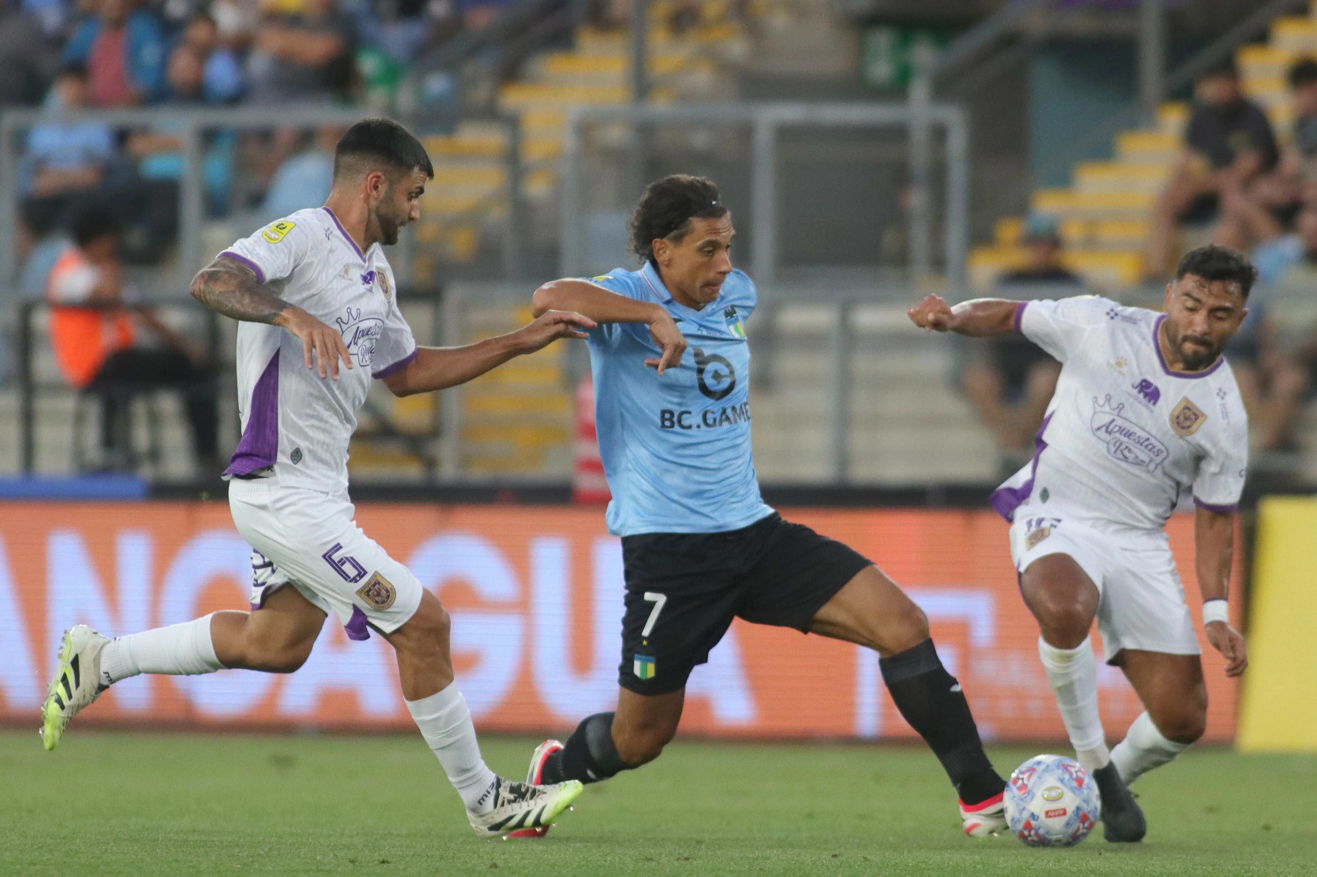 Mauricio Vera marca a Martín Sarrafiore junto a Mario Sandoval en un duelo entre Concepción vs O’Higgins. (Jorge Loyola/Photosport).
