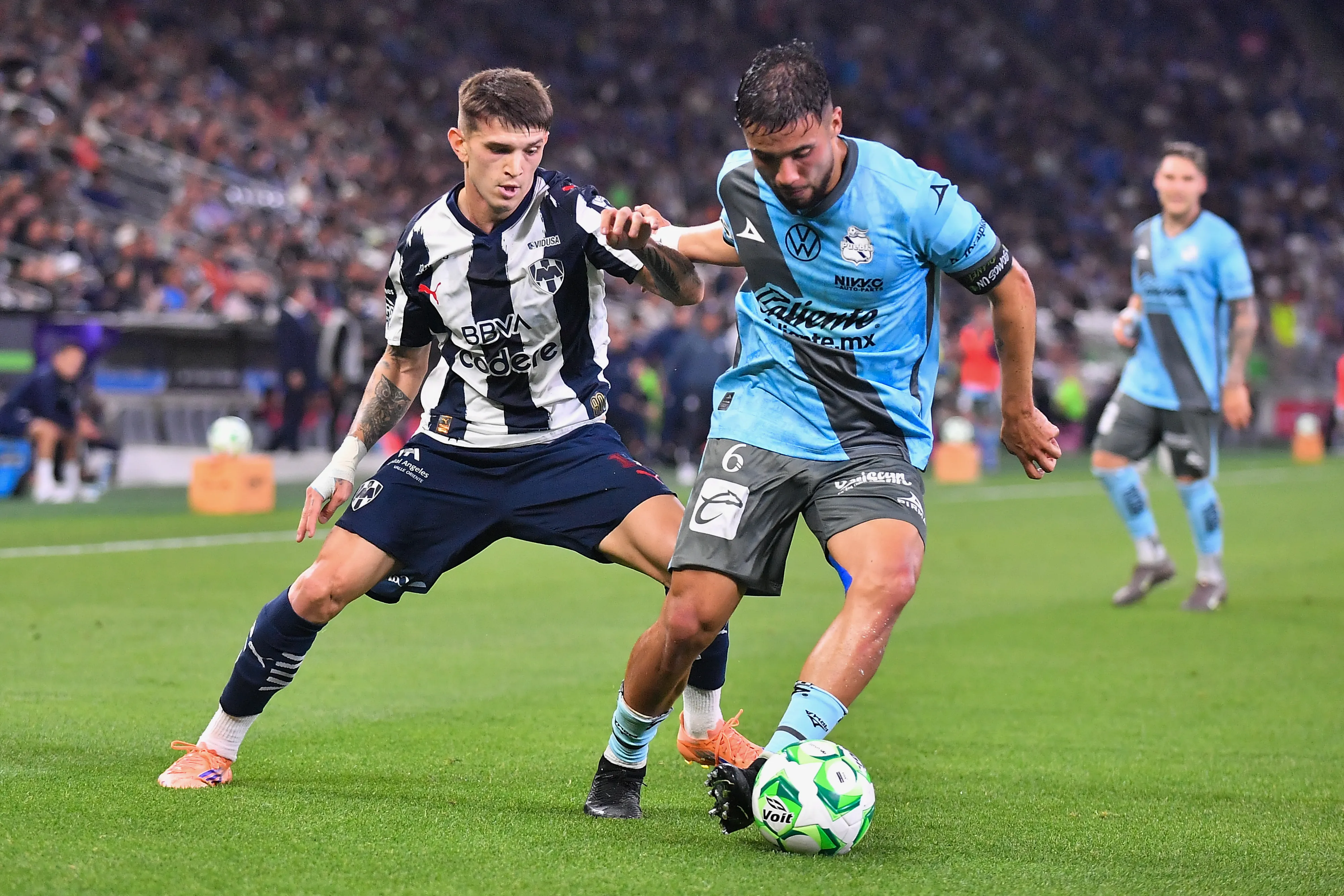 Nicolás Díaz por el Puebla aguanta la pelota ante la presión del argentino Luca Orellano de Monterrey. (Azael Rodriguez/Getty Images).