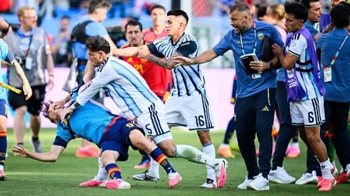 Thiago Almada intenta parar a Leandro Paredes.