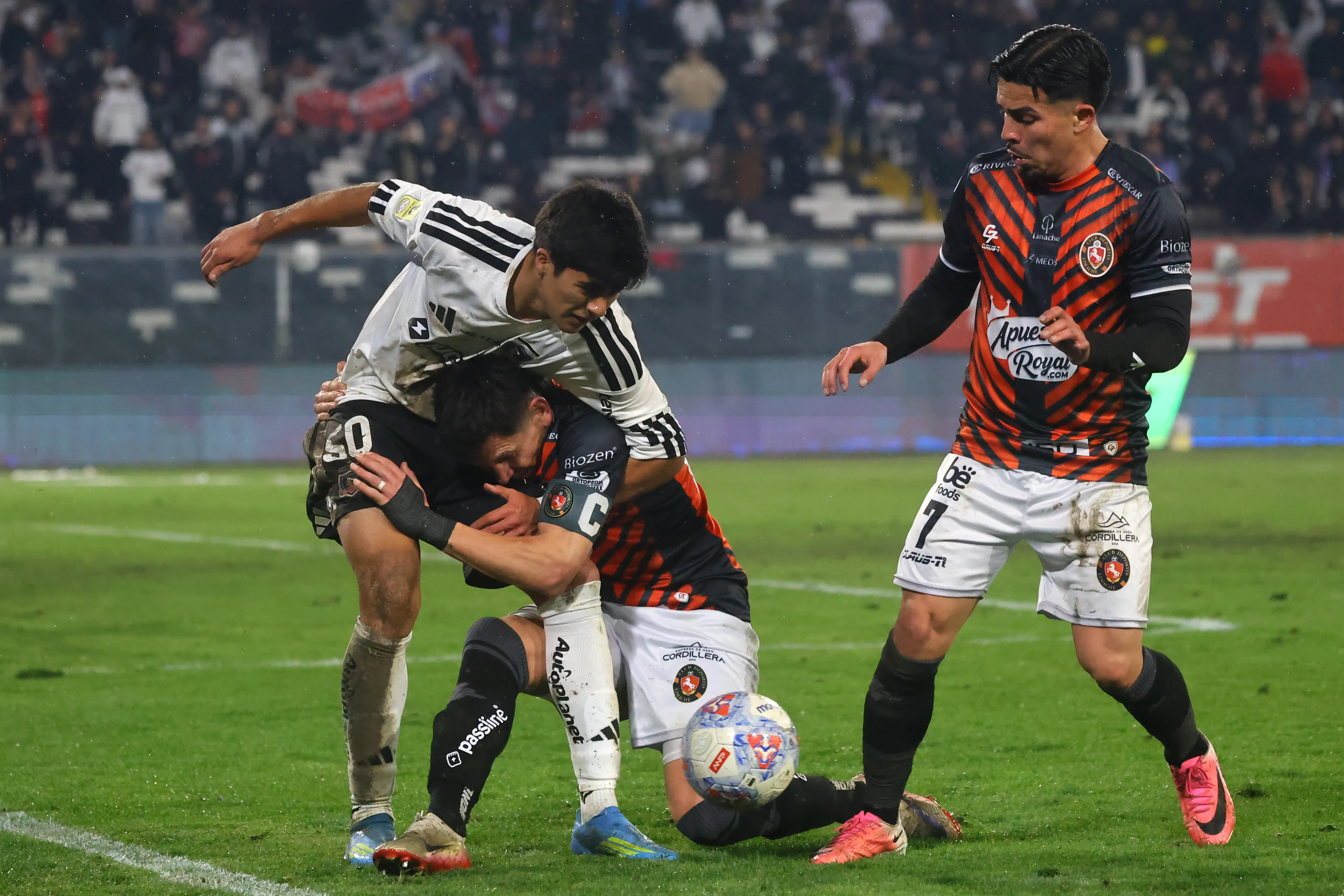 Alfonso Parot forcejea ante Felipe Raipán y Carlos Morales mira la acción. (Jonnathan Oyarzun/Photosport).