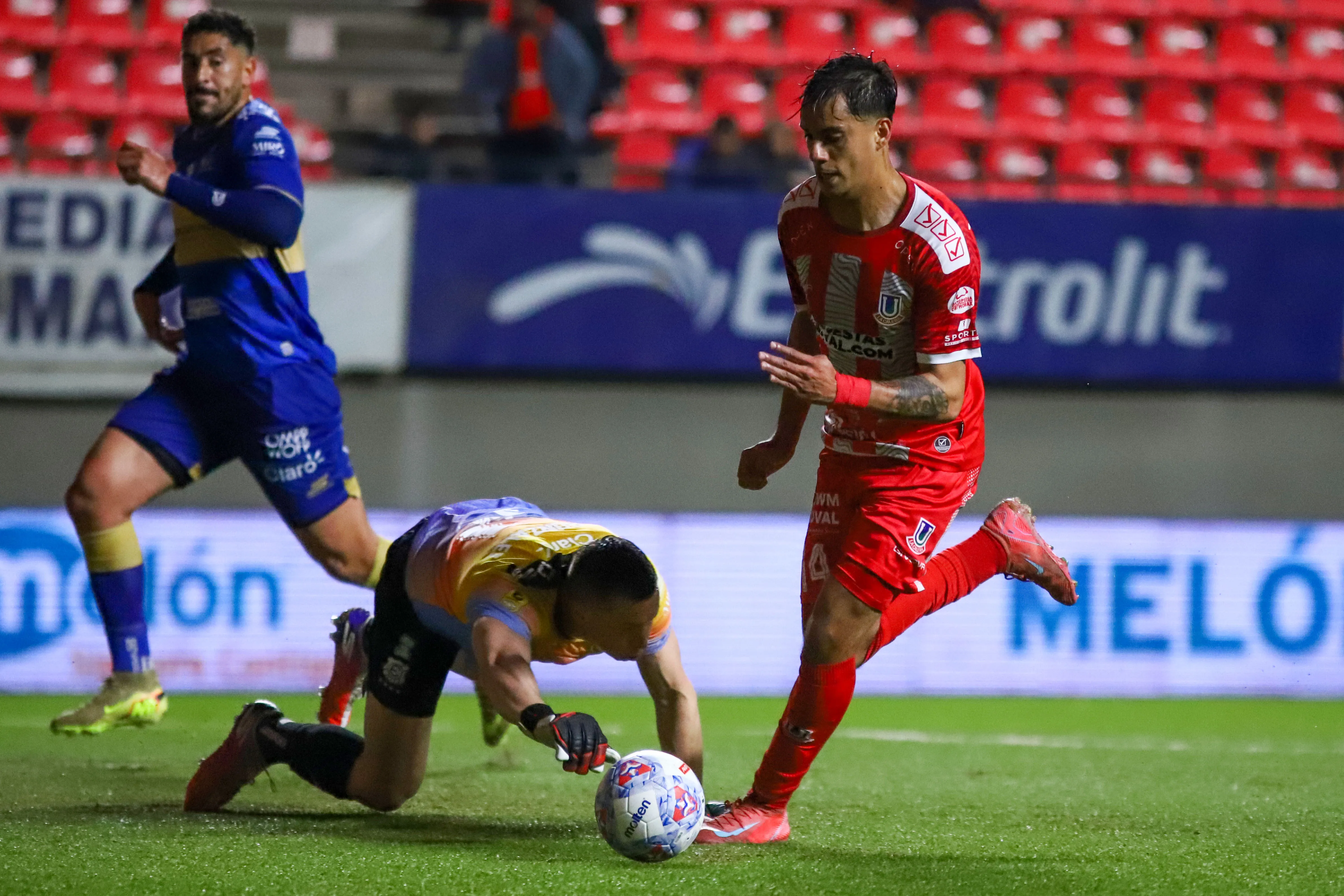 Nacho González va por la pelota ante el asedio de Carlo Villanueva. (Manuel Lema/Photosport).