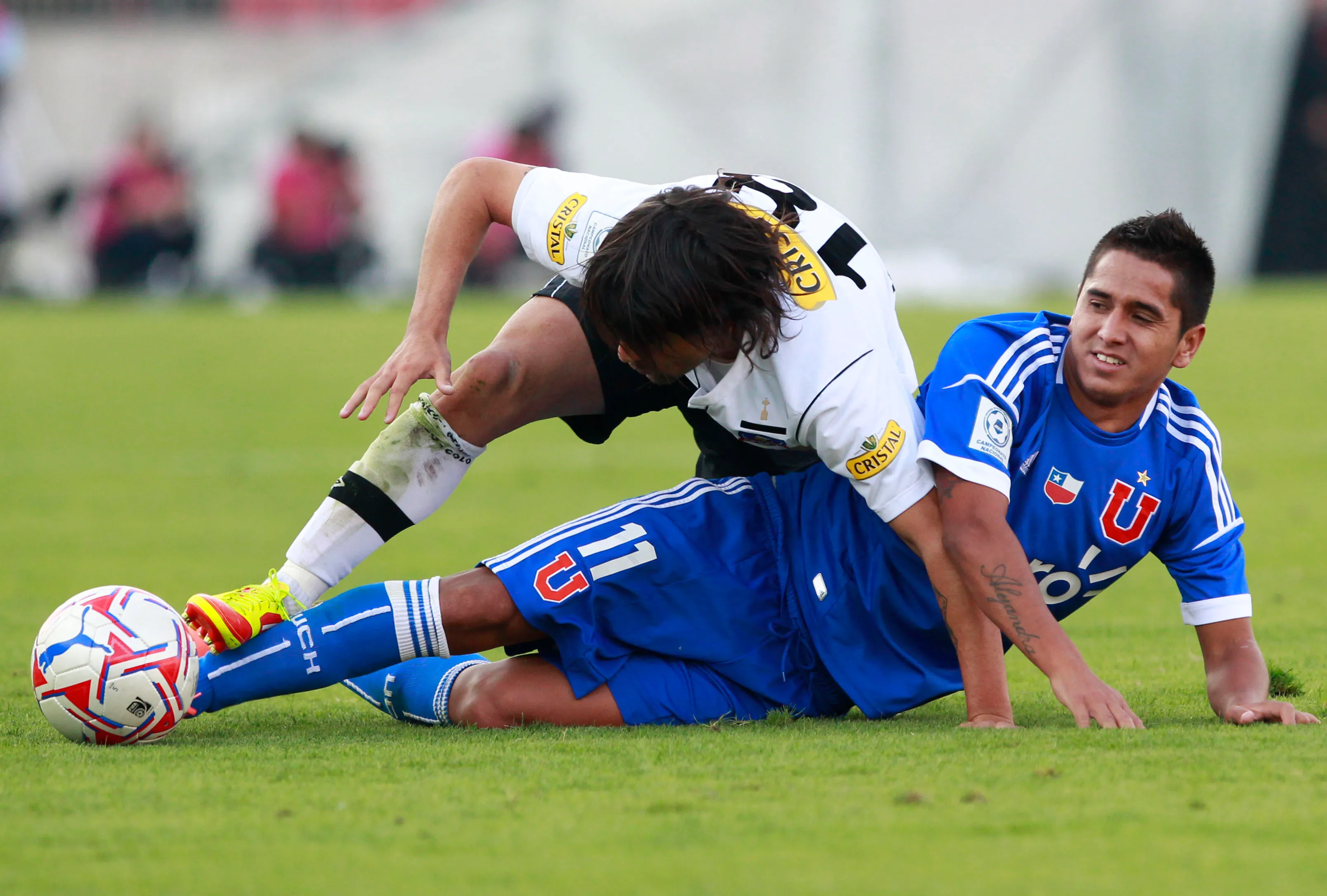 Lucas Wilchez lucha un balón contra Emilio Hernández en un clásico disputado en 2012. (Marcelo Hernández | Photosport).