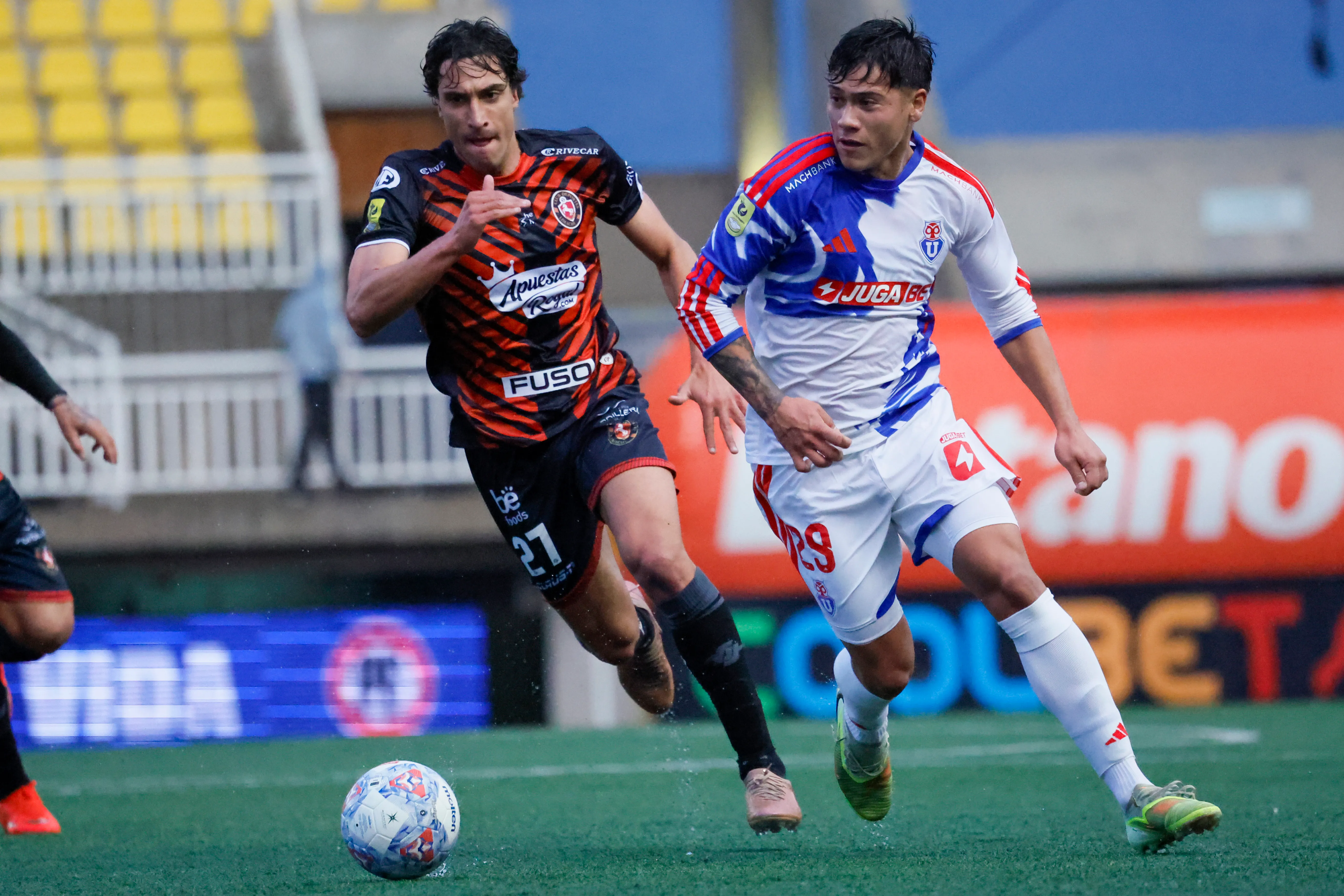 Lucas Barrera avanza en la cancha mientras el uruguayo Tiago Galetto lo persigue. (Andrés Pina/Photosport).