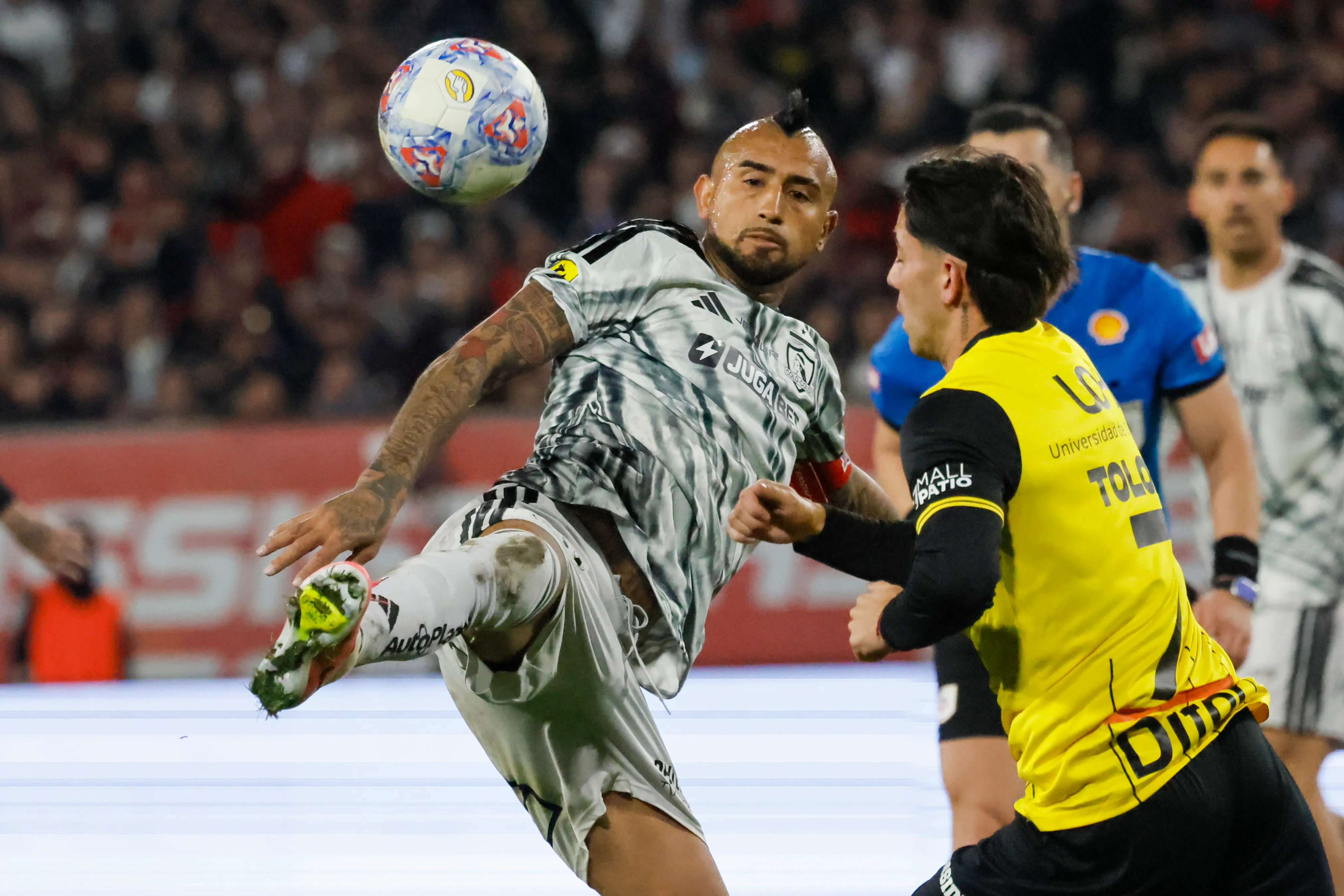 Arturo Vidal en acción ante Santiago Toloza, uno de los refuerzos que se estrenó en O’Higgins. (Andrés Piña/Photosport).