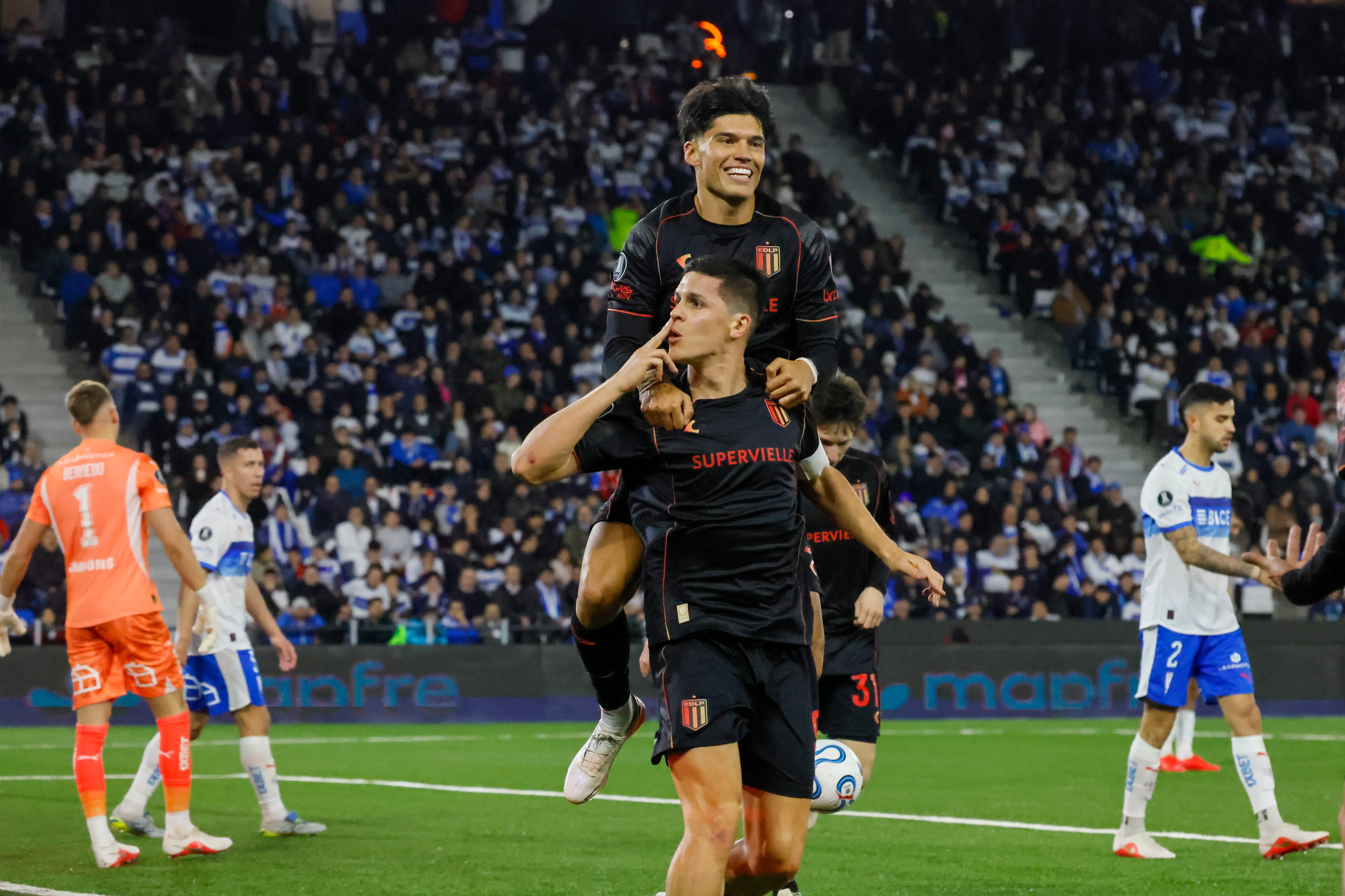 El Tucu Correa monta la espalda de Guido Carrillo, autor de dos goles en el Claro Arena. (Andrés Piña/Photosport).