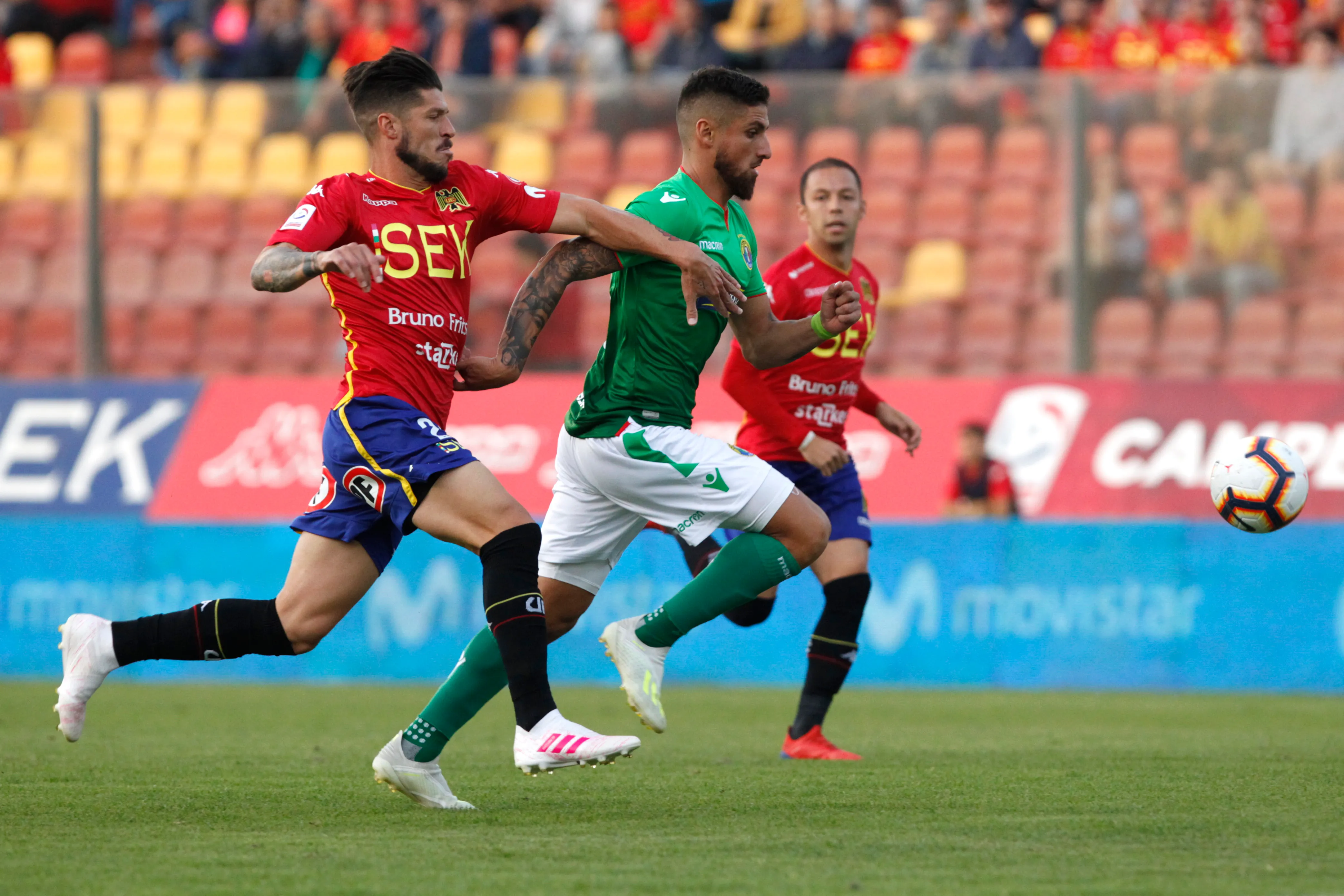 Carlos Matheu intenta frenar el avance de Ignacio Jeraldino en un clásico de colonia entre Unión Española y Audax Italiano. (Ramon Monroy/Photosport).