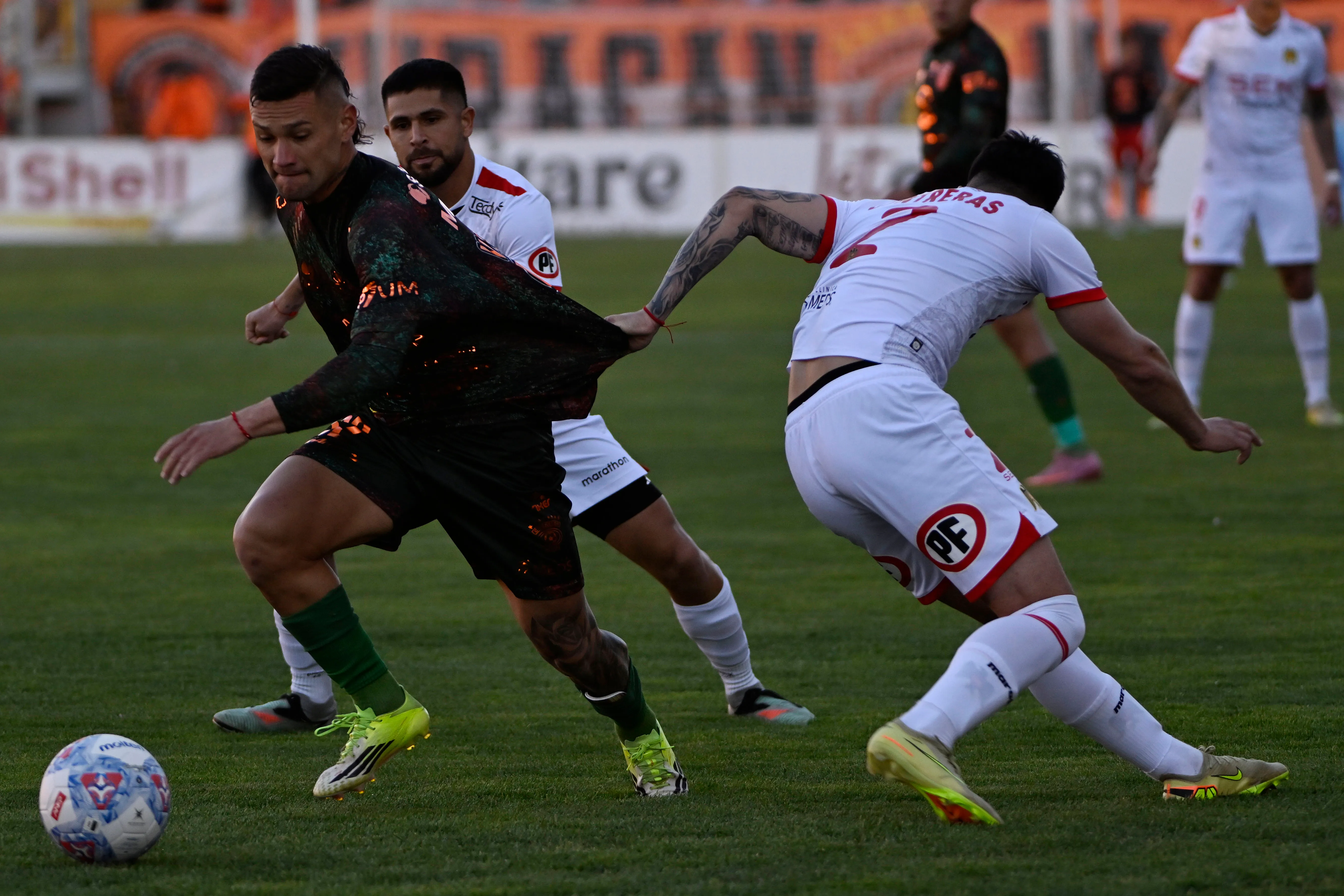 Kevin Contreras intenta frenar a Facundo Velazco de cualquier manera. (Pedro Tapia/Photosport).