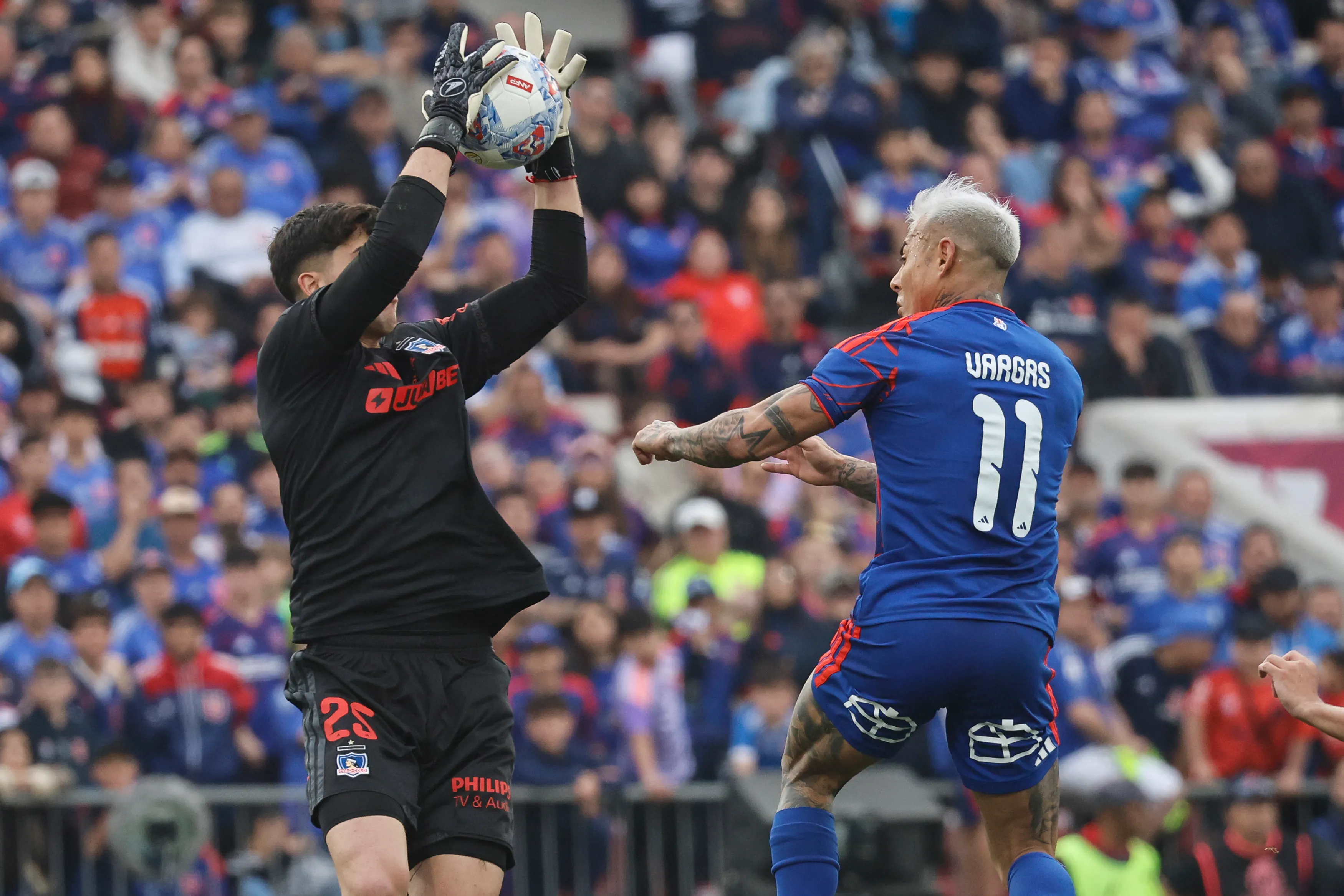 Gabriel Maureira descuelga una pelota aérea ante el asedio de Eduardo Vargas. (Diego Martin/Photosport).