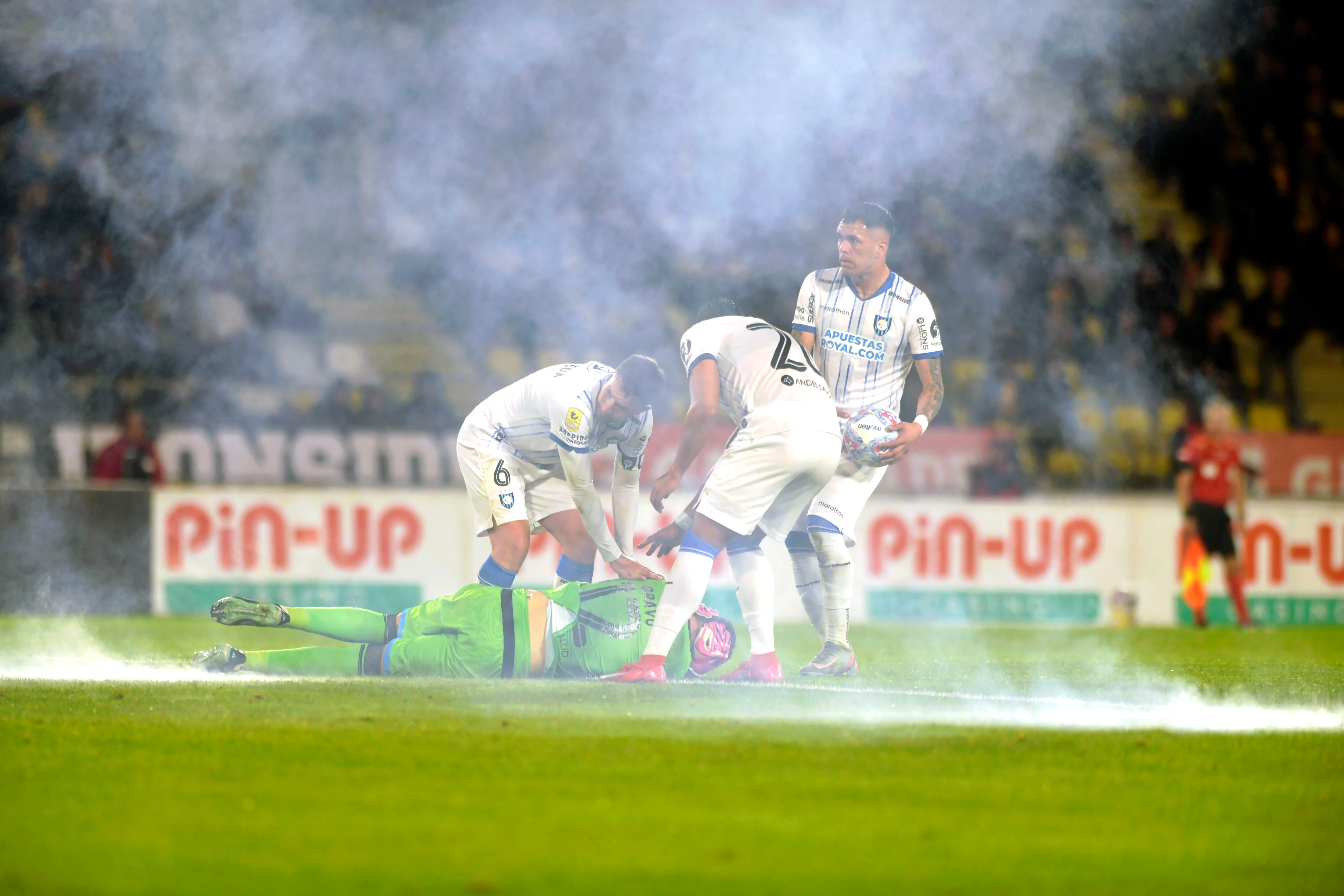 Varios jugadores de Huachipato se acercaron a intentar asistir a Christian Bravo tras las explosiones. (Alejandro Pizarro Ubilla/Photosport).