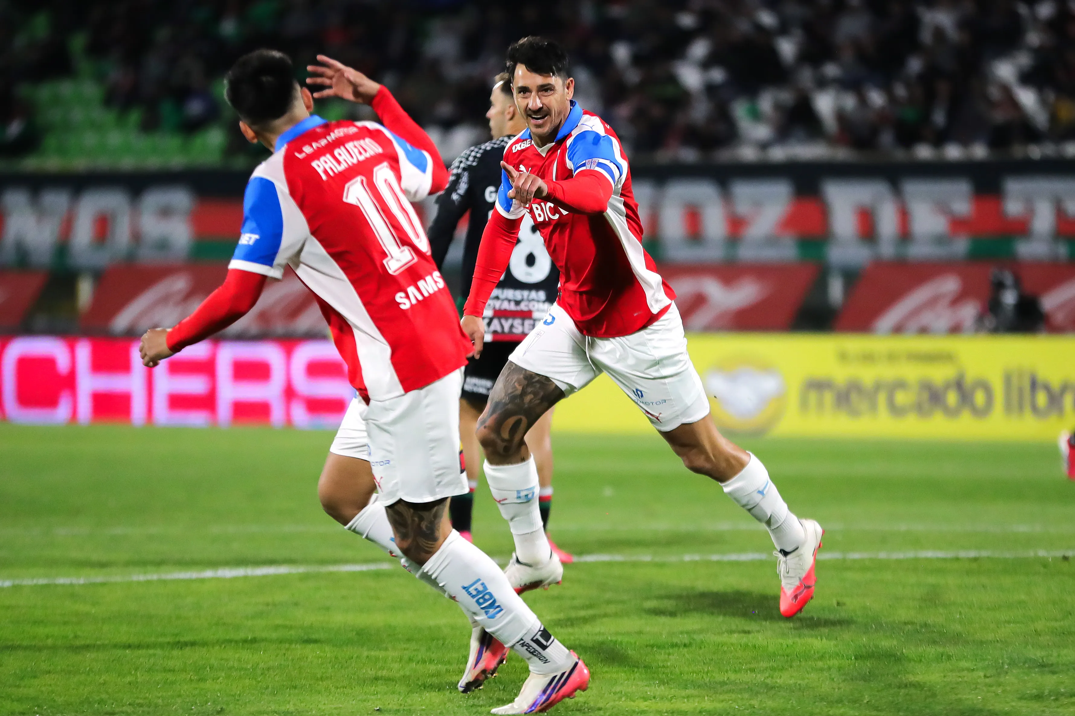 Fernando Zampedri felicita a Matías Palavecino tras el 1-0 que le anotó a Palestino. (Felipe Zanca/Photosport).