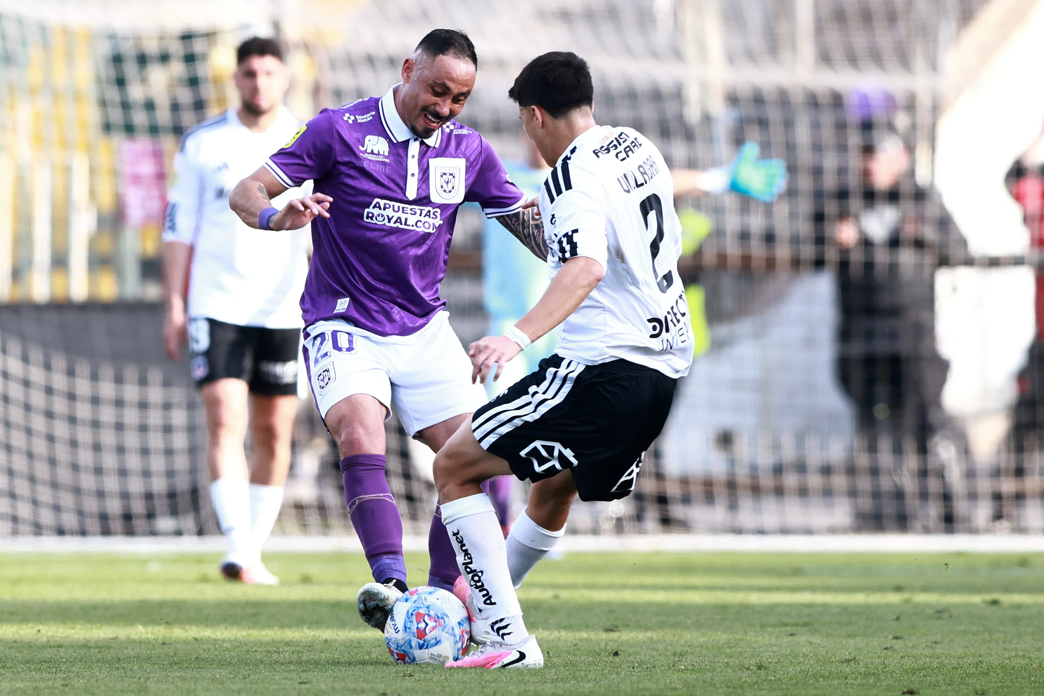 Jonathan Villagra tranca una pelota con Jorge Henríquez, autor de la asistencia para Norman Rodríguez en el gol de los lilas. (Felipe Zanca/Photosport).