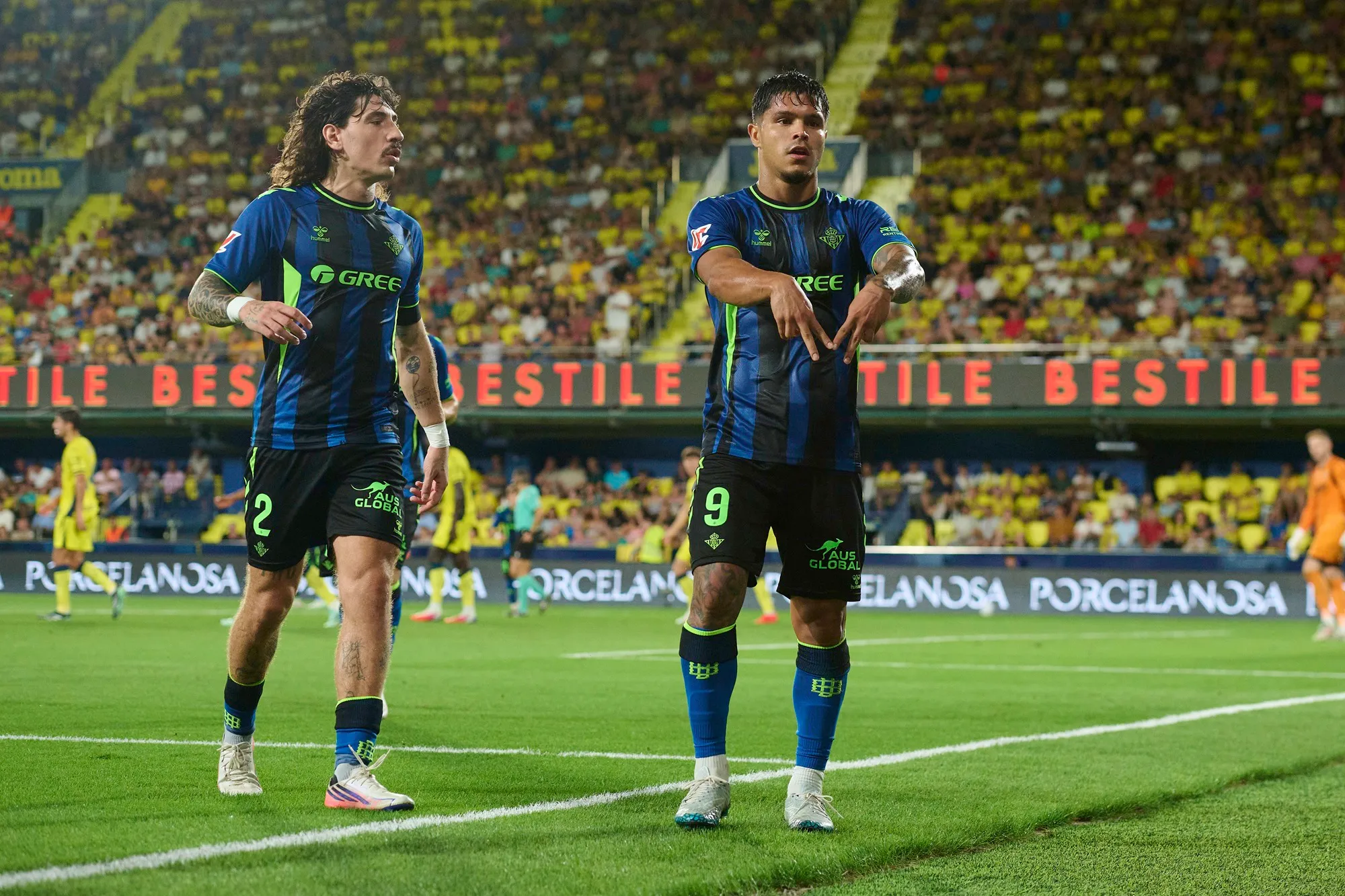 El cafetalero Juan Camilo Hernández celebra junto a Héctor Bellerín el 1-1 parcial. (Francisco Macia/Getty Images).