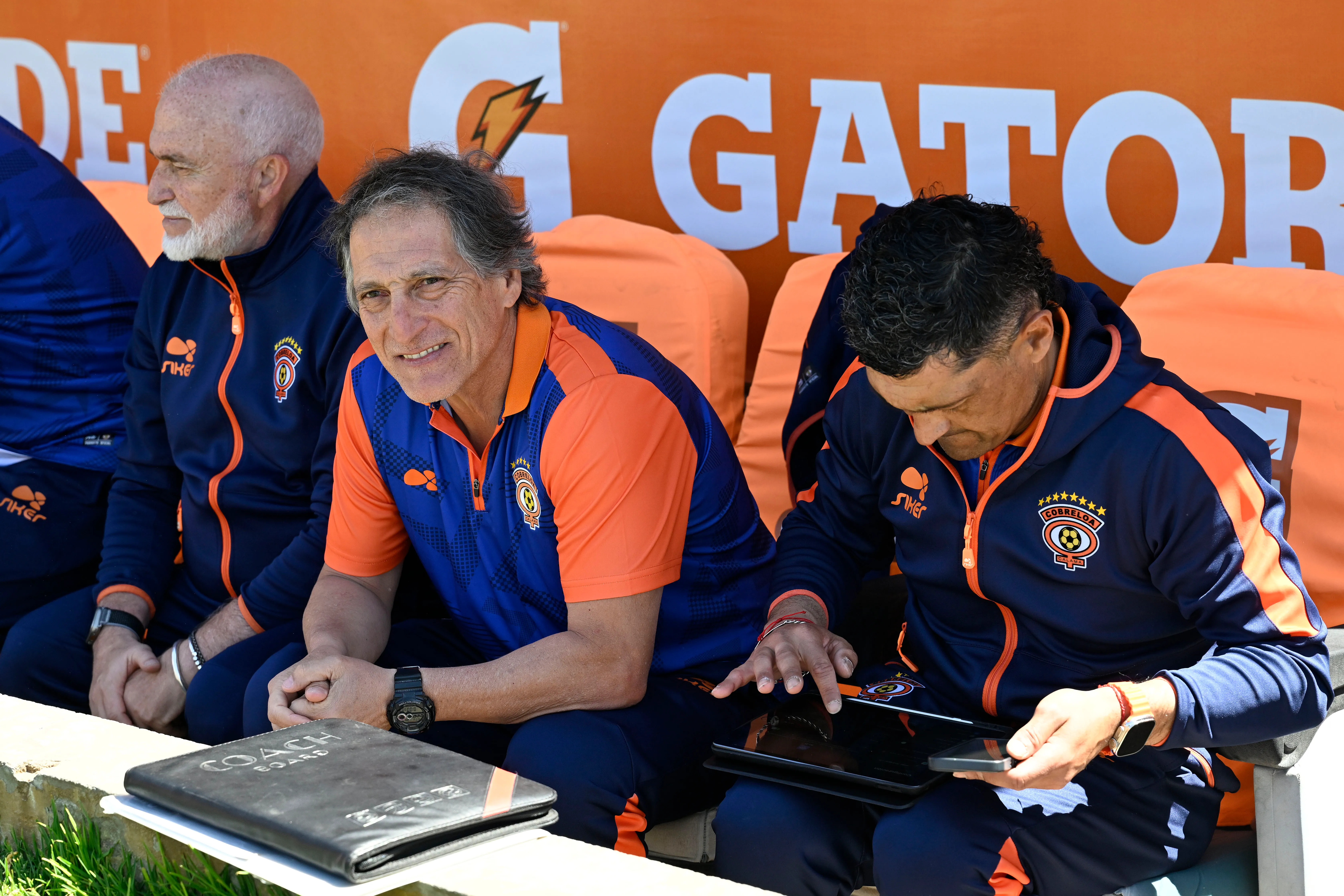 Mario Salas junto a Marcelo Rosemblat, su PF y a Javier Rodríguez, el entrenador de arqueros que mira una pantalla. (Pedro Tapia/Photosport).