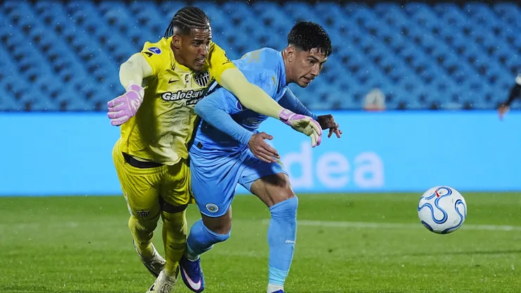 Salomón Rodríguez lucha un balón con el portero Gabriel Delfim.