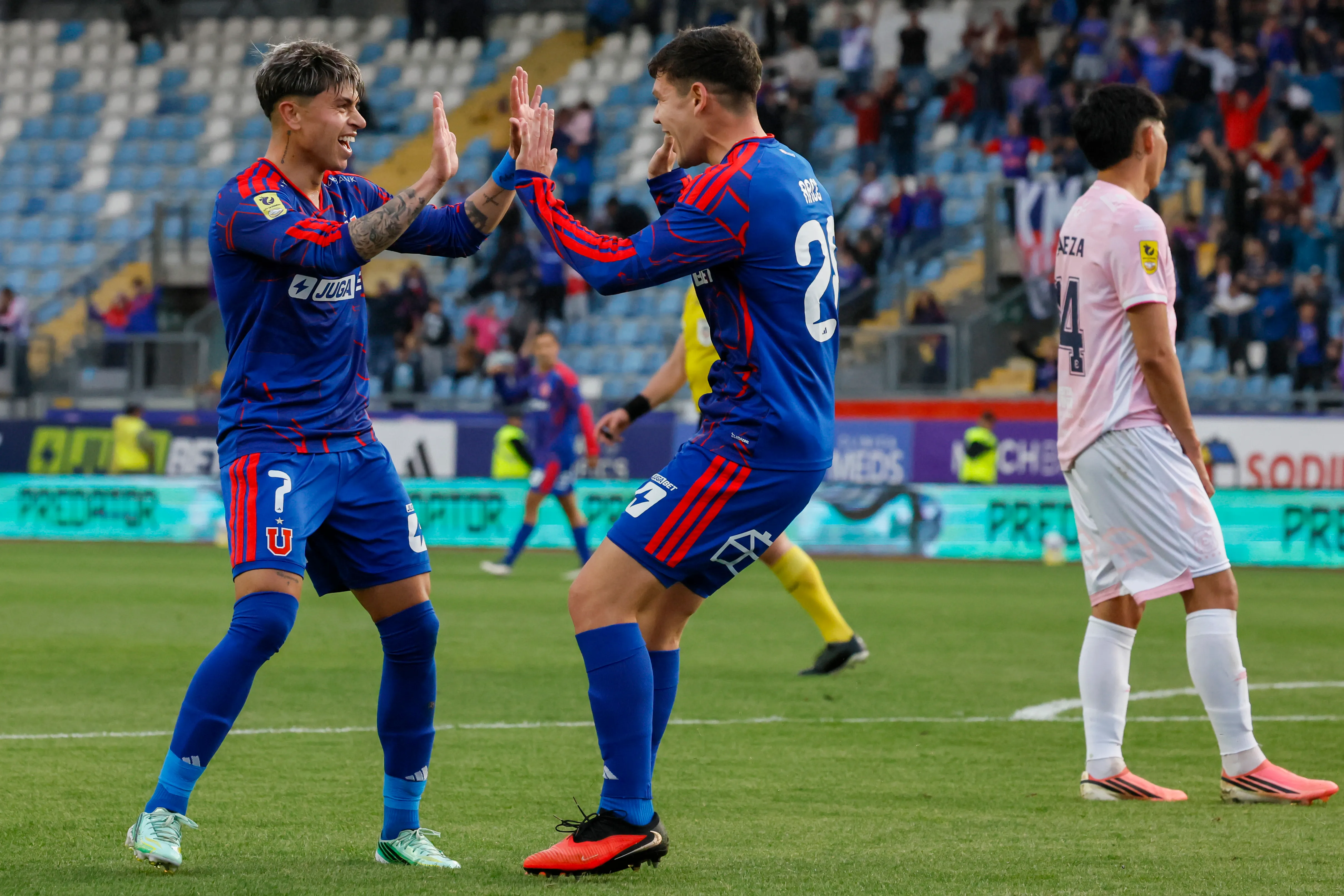 Agustín Arce celebra con Maxi Guerrero, autor de cuatro asistencias en El Teniente. (Andrés Piña/Photosport)