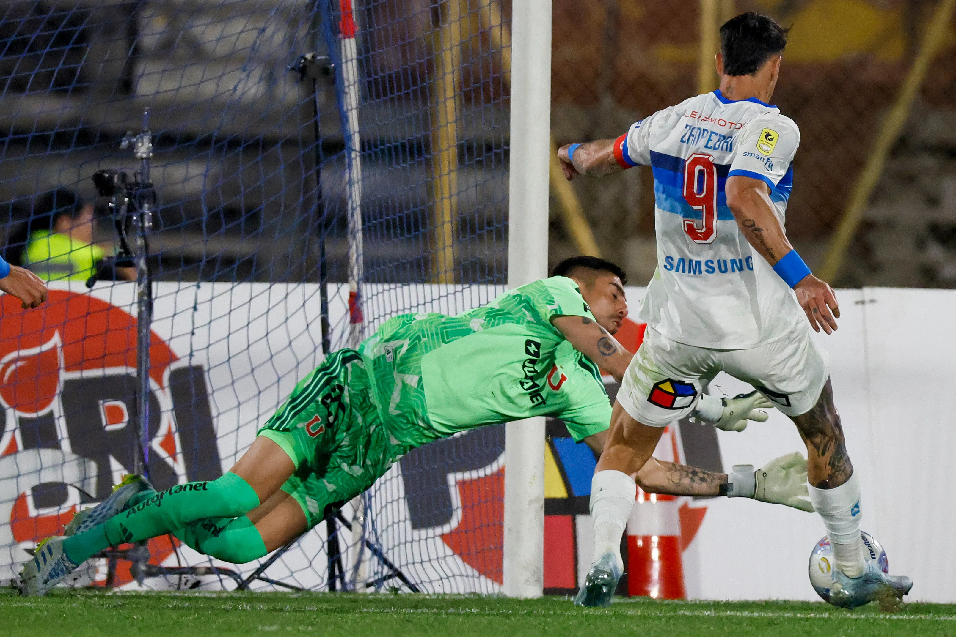 Fernando Zampedri ante el achique de Gabriel Castellón en el Clásico Universitario de la primera rueda. (Andrés Piña/Photosport).